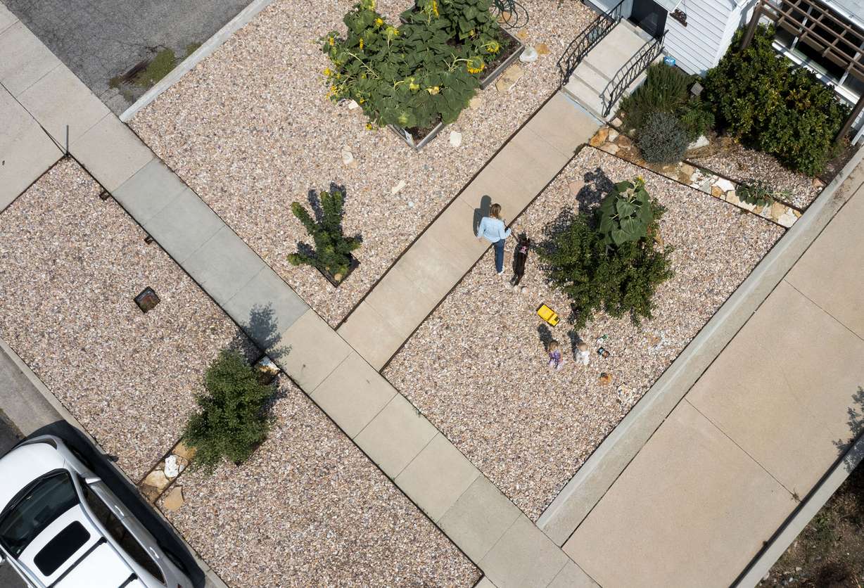 Rachel Simeon and her daughters are photographed on their Salt Lake City property on Friday, Aug. 20, 2021. Simeon says she was dumbfounded when she got a letter from Salt Lake City code enforcement, in the midst of Utah's historic drought, that she needed to add more vegetation to her park strip, which would require more water.