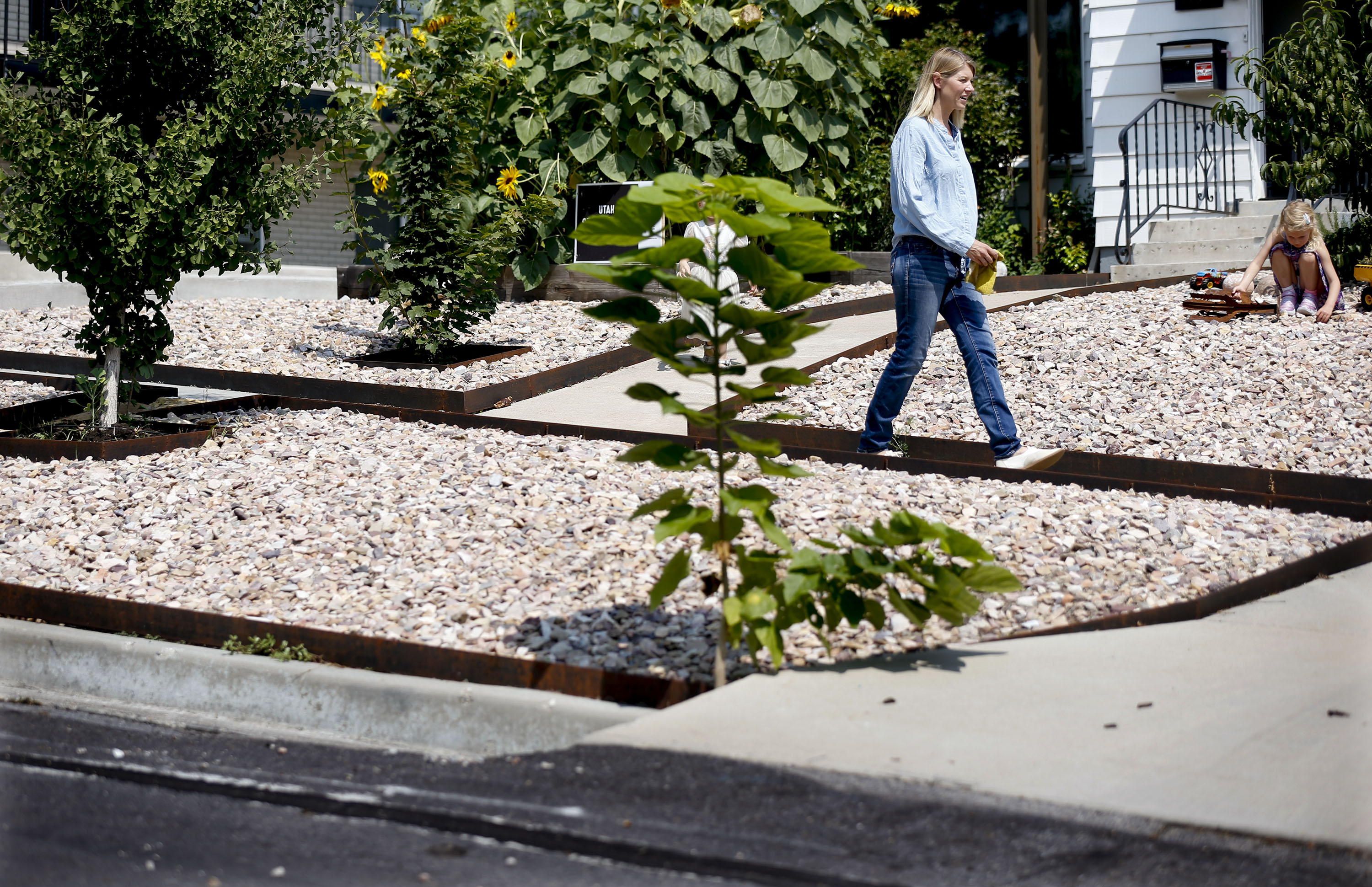 Rachel Simeon walks down the sidewalk at her Salt Lake City home on Friday, Aug. 20, 2021. The Salt Lake City Council is mulling changes to its landscaping regulations that could allow for more xeriscaping. 