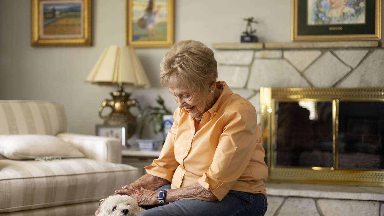 Patti Edwards, wife the late LaVell Edwards, pets her dog, Doodle, at her home in Provo on Thursday, Sept. 1.