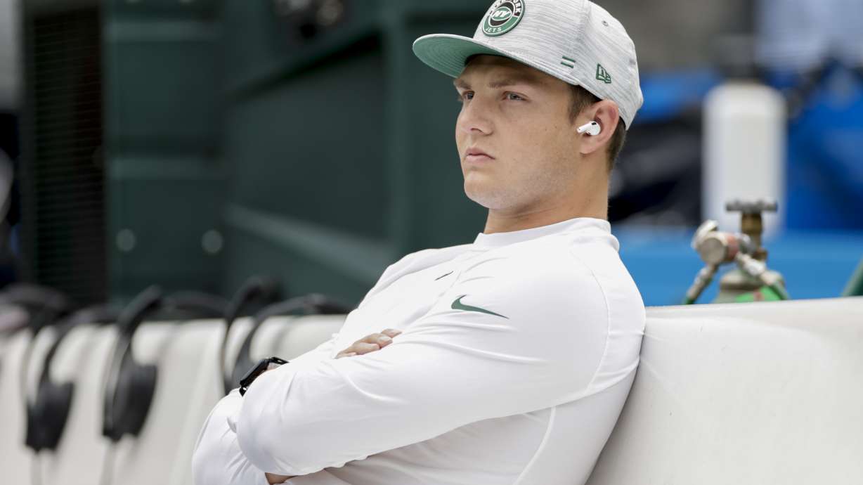 New York Jets quarterback Zach Wilson sits on the bench during practice before a preseason NFL football game against the New York Giants, Sunday, Aug. 28, 2022, in East Rutherford, N.J.