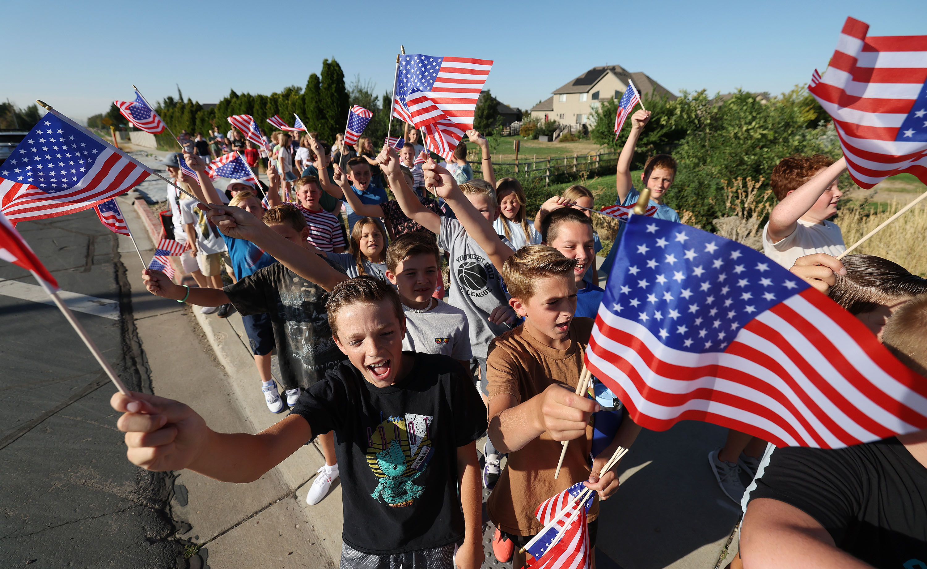 Canyon Creek Elementary sixth graders wave their flags at motorists as they walk to the "Davis Remembers" 9/11 museum exhibit at the Legacy Events Center in Farmington on Wednesday.