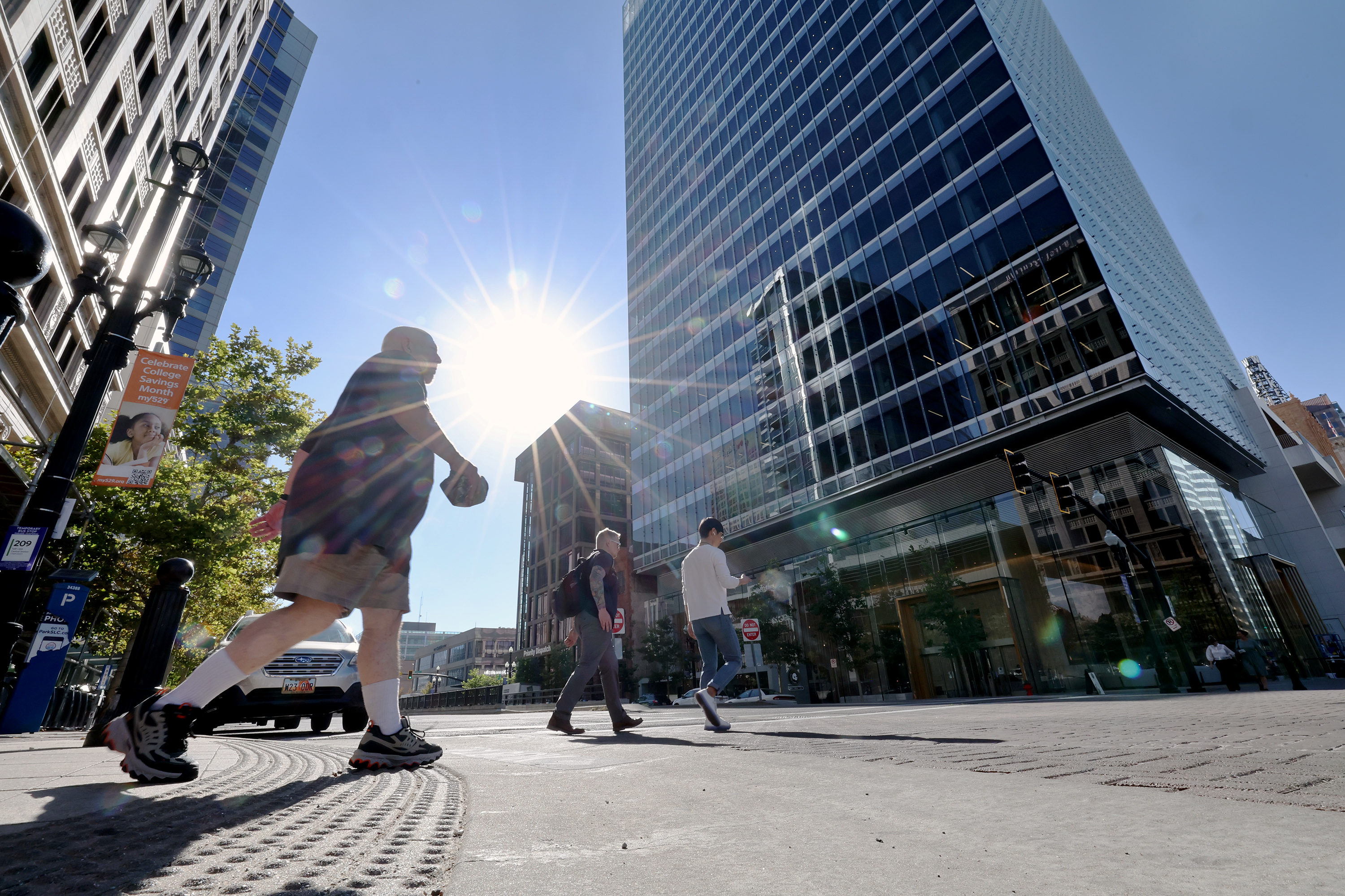 The sun shines on a hot day as people walk in Salt Lake City on Sept. 6, 2022. Salt Lake City is currently forecast to have its first 100-degree day of the year on Monday.