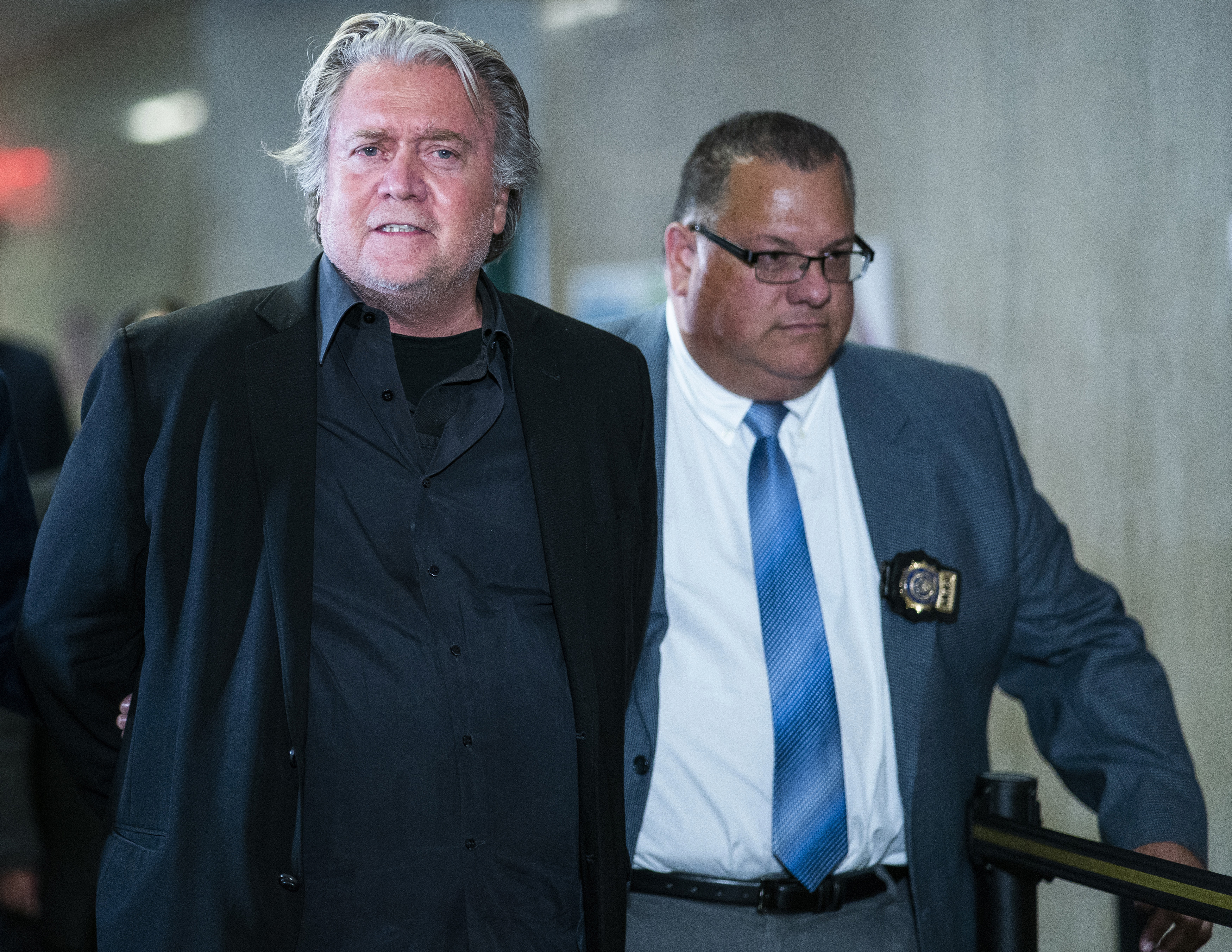 Former White House strategist Steve Bannon is escorted along the hall to go into the courtroom of the Manhattan district attorney's office after surrendering to New York authorities, Thursday, in New York.