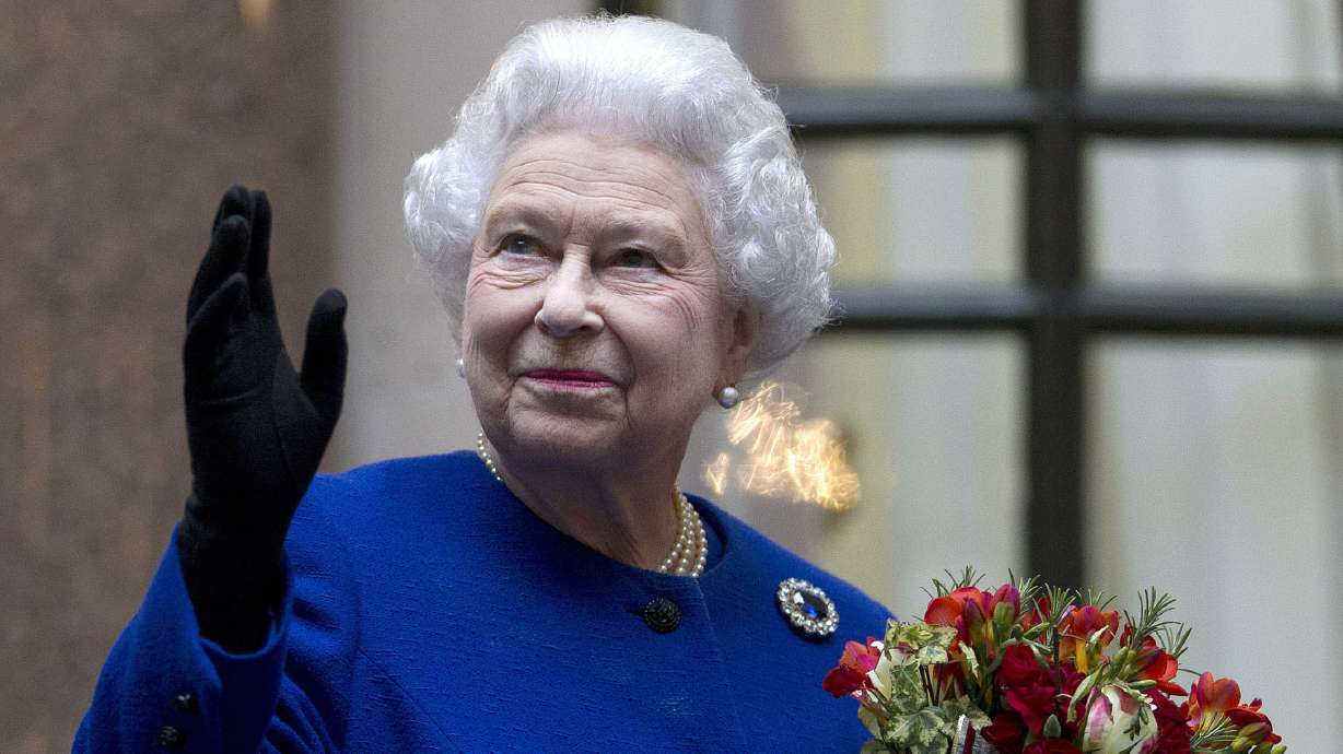 Britain's Queen Elizabeth II looks up and waves to members of staff of the Foreign and Commonwealth Office as she ends an official visit which is part of her Jubilee celebrations in London, Dec. 18, 2012. Queen Elizabeth II, Britain’s longest-reigning monarch and a symbol of stability across much of a turbulent century, has died on Thursday.