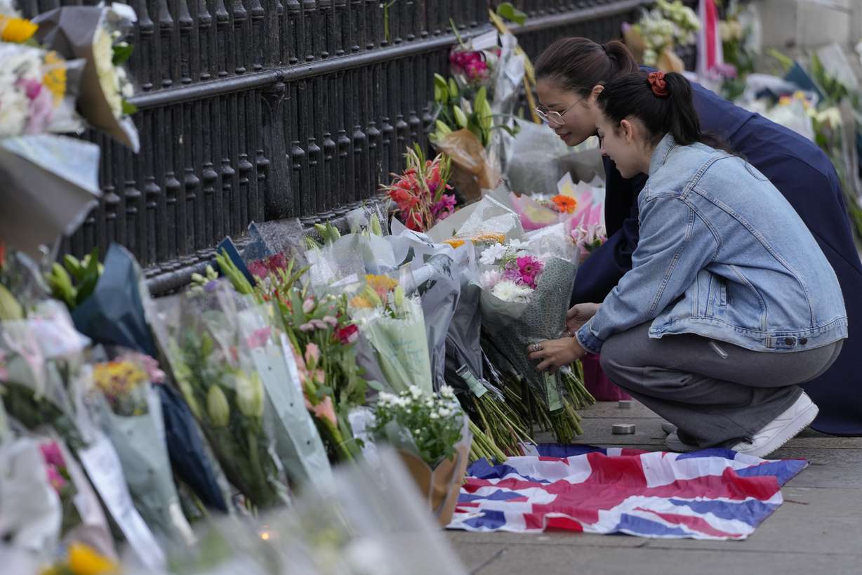 Mourners lay flowers outside Buckingham Palace in London, Friday. Queen Elizabeth II, Britain's longest-reigning monarch and a rock of stability across much of a turbulent century, died Thursday after 70 years on the throne. She was 96.