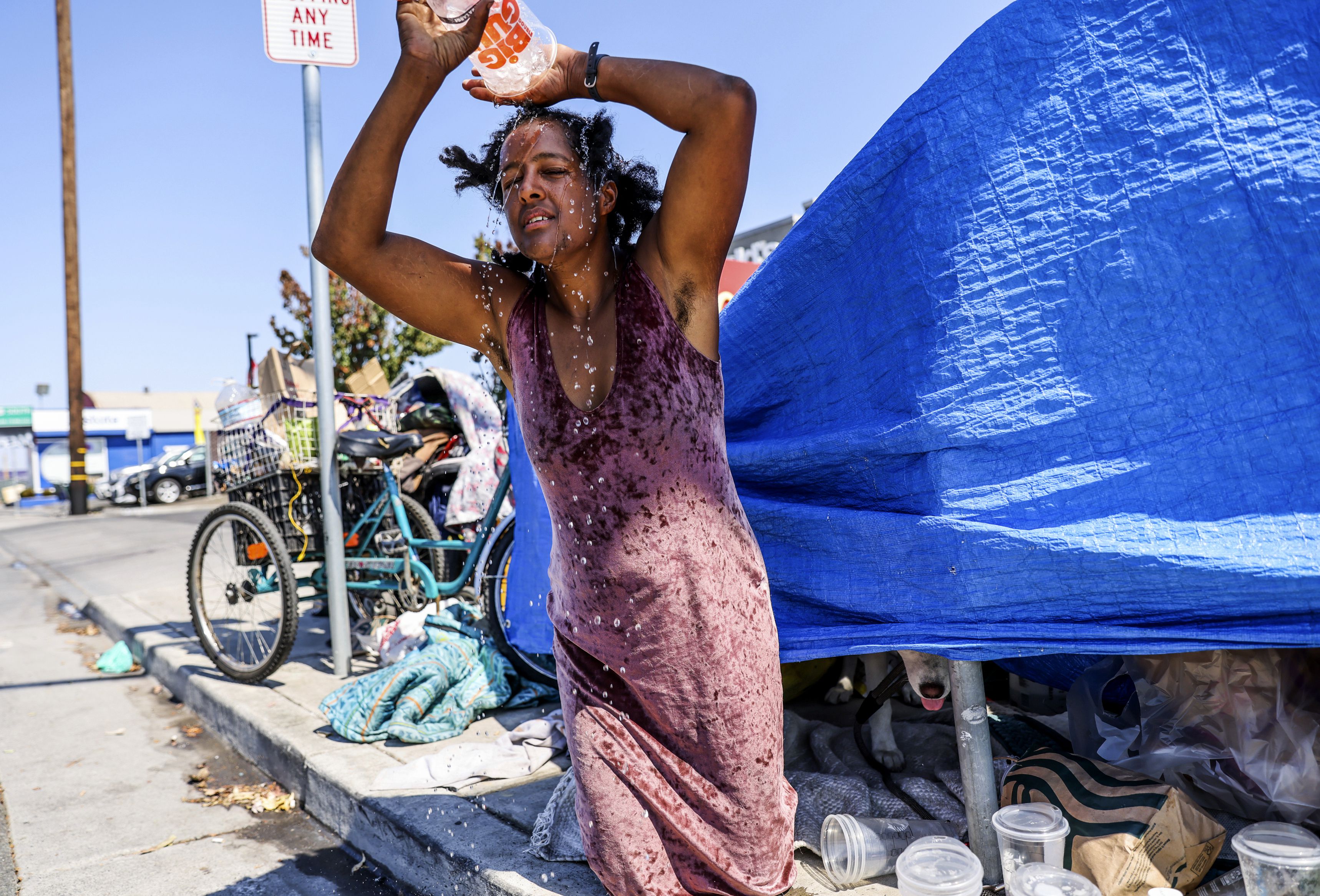 Angel Martinez, who has been homeless on and off for several years, pours ice water on her head in an attempt to stay cool in the scorching heat in Santa Rosa, Calif., on Wednesday.