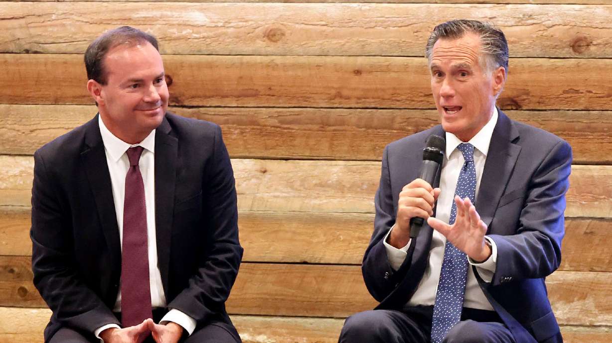 Sen. Mike Lee, R-Utah, listens as Sen. Mike Romney, R-Utah, center, addresses the South Valley Chamber of Commerce gathering at the Salt Mine Productive Workspace in Sandy on Aug. 18.
