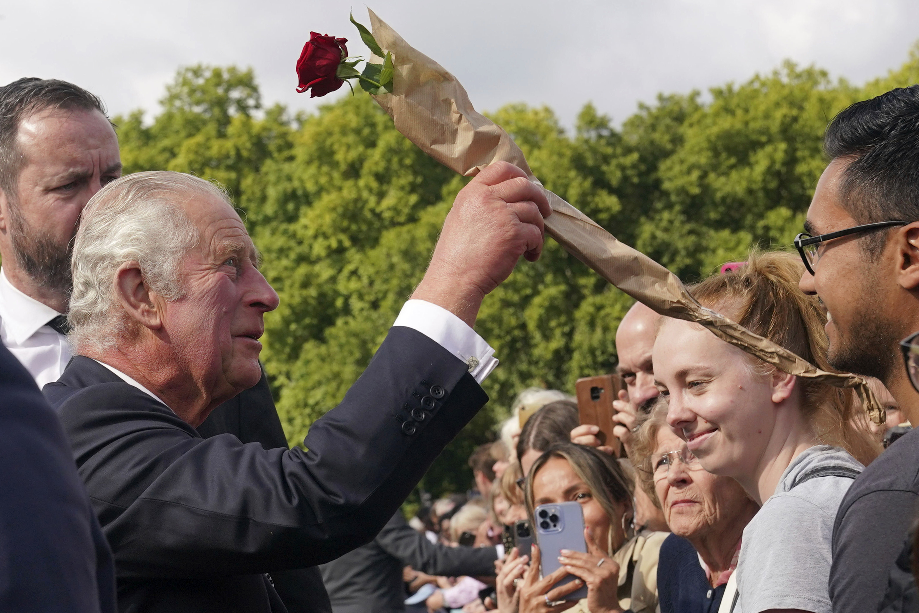 Britain's King Charles III is given a rose by well-wishers outside Buckingham Palace following Thursday's death of Queen Elizabeth II, in London, Friday. King Charles III, who spent much of his 73 years preparing for the role, planned to meet with the prime minister and address a nation grieving the only British monarch most of the world had known. He takes the throne in an era of uncertainty for both his country and the monarchy itself.