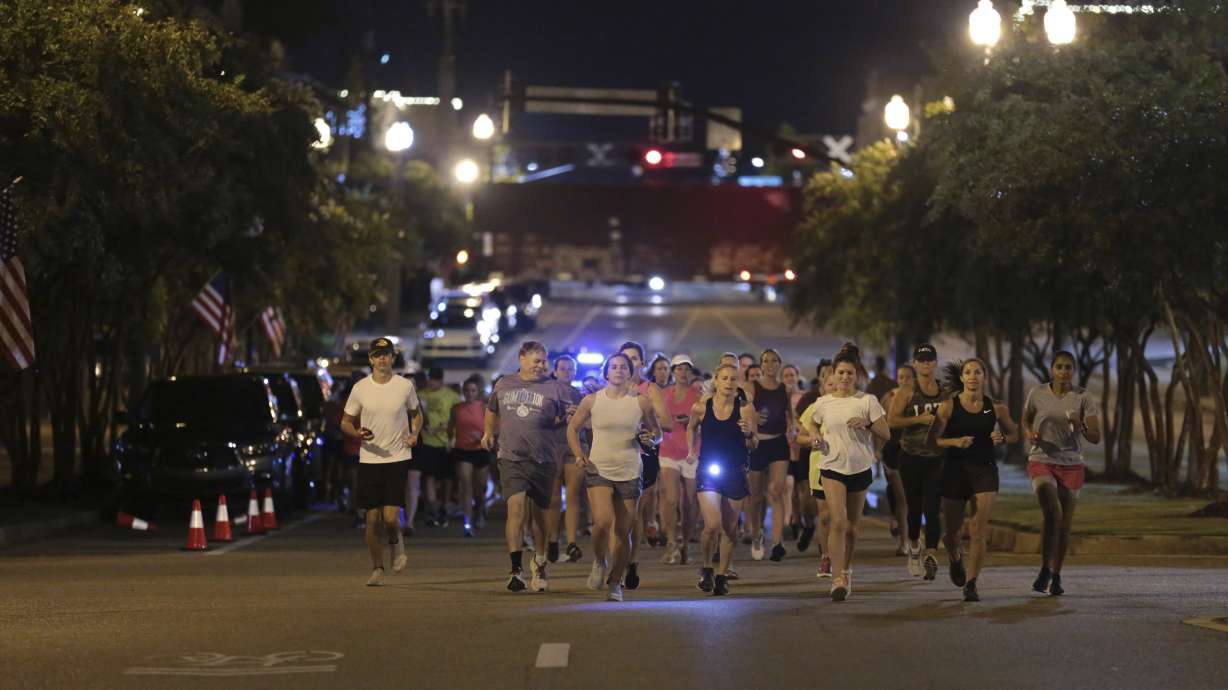 Runners make their way down Main Street in Tupelo, Miss. as they hold their "Liza's Lights" run early Friday morning, in Tupelo Miss., to remember Eliza Fletcher, who was abducted and murdered while she was running in the early morning hours in Memphis, Tenn.