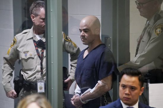 Clark County Public Administrator Robert "Rob" Telles is escorted into court, Thursday, in Las Vegas. Telles was arrested Wednesday in the fatal stabbing of Las Vegas Review-Journal reporter Jeff German, whose investigations of the official's work preceded his primary loss in June.