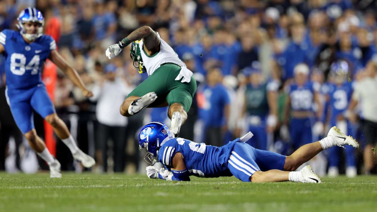 Baylor Bears wide receiver Gavin Holmes (6) is tripped up by Brigham Young Cougars defensive back Jacob Boren (20) on a punt play as BYU and Baylor play at LaVell Edwards Stadium in Provo on Saturday, Sept. 10, 2022.