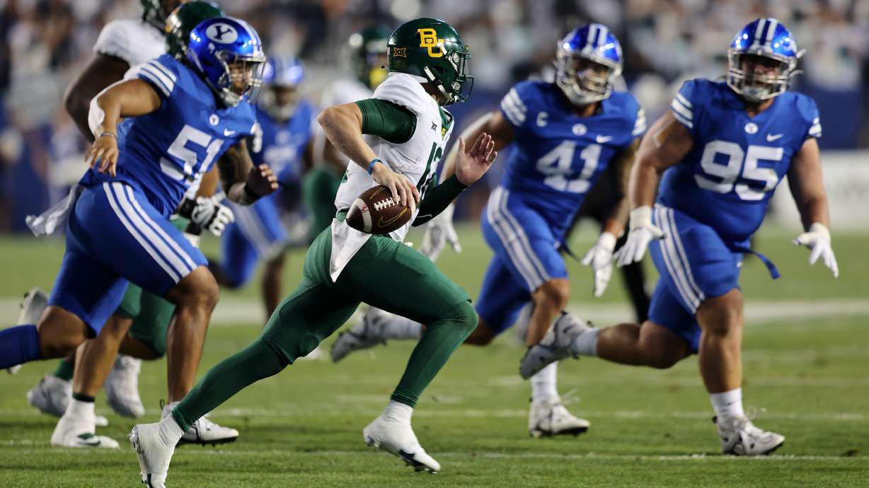 Brigham Young Cougars defensive members chase Baylor Bears quarterback Blake Shapen (12) as BYU and Baylor play at LaVell Edwards Stadium in Provo on Saturday, Sept. 10, 2022.