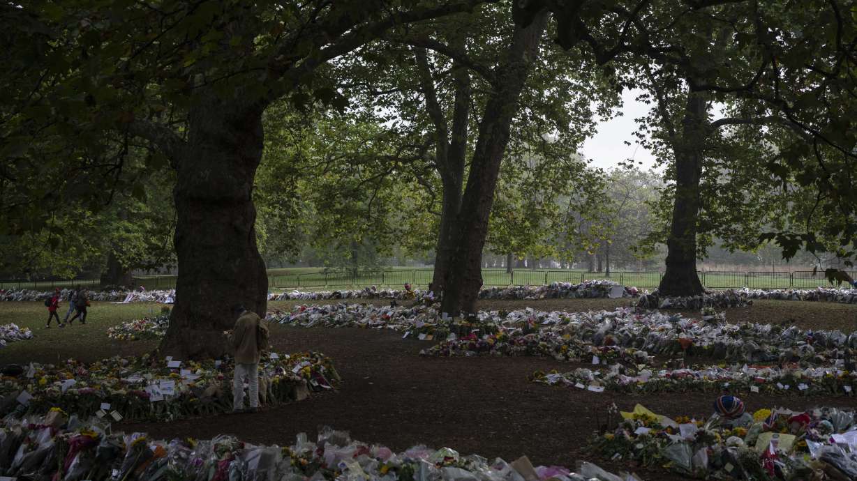 Mourners lay flowers for Queen Elizabeth II at Green Park, near Buckingham Palace in London, Sunday.