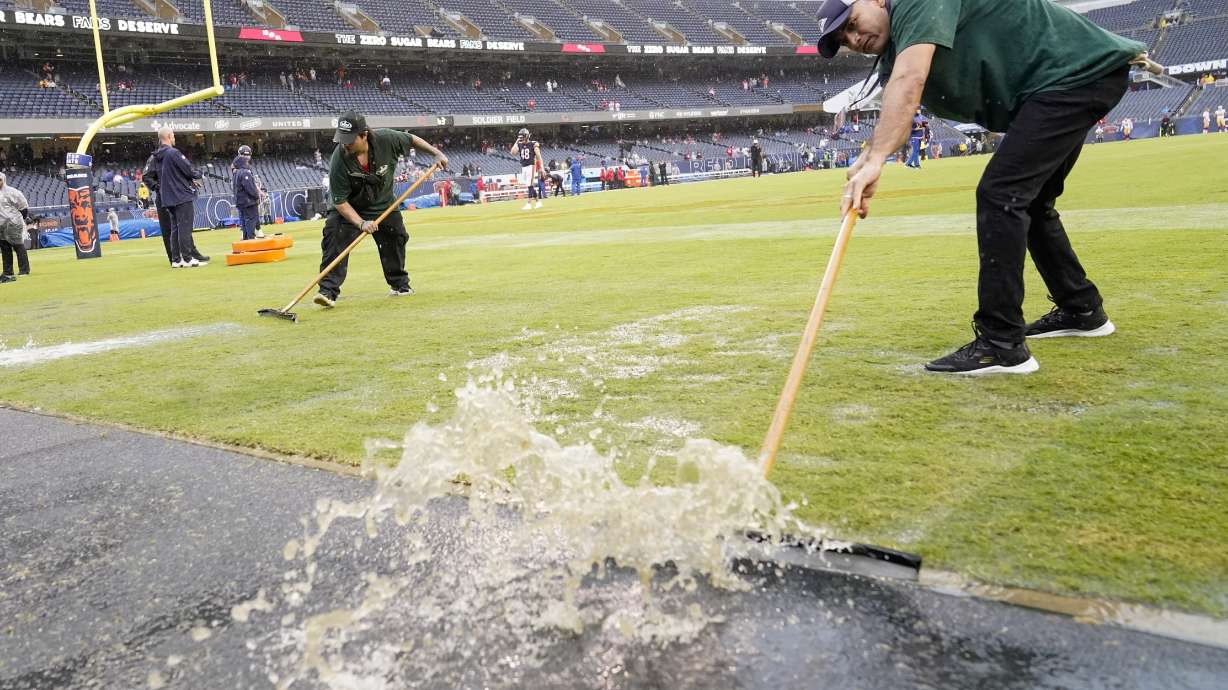 Workers remove water from Soldier Field before an NFL football game between the Chicago Bears and the San Francisco 49ers Sunday, Sept. 11, 2022, in Chicago.