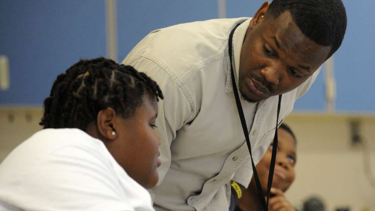 Timothy Allison, a collaborative special education teacher in Birmingham, Ala., works with a student at Sun Valley Elementary School on Thursday. The school district is struggling to fill around 50 teaching spots, including 15 in special education, despite $10,000 signing bonuses for special education teachers.