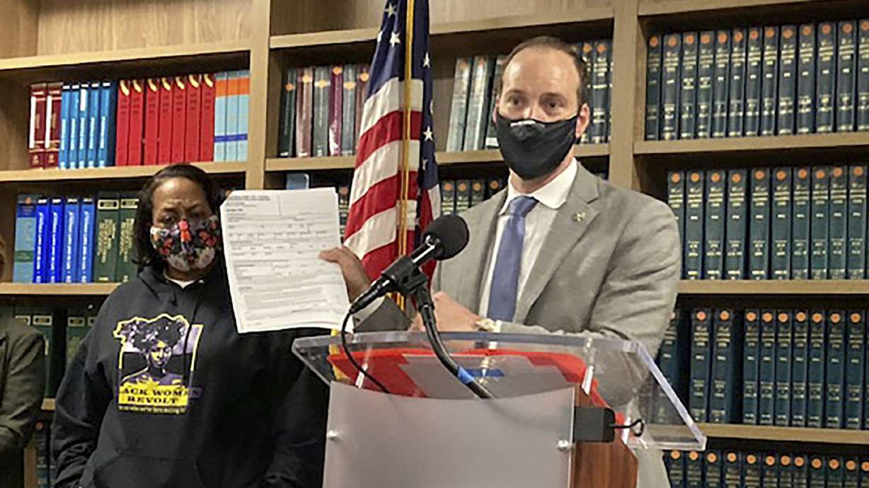 Former San Francisco District Attorney Chesa Boudin holds a report during a news conference in San Francisco on Feb. 15. Boudin said the report showed DNA collected by San Francisco police from a woman who was sexually assaulted was used by police detectives to arrest her years later in an unrelated property crime. Attorney Adante Pointer said Monday he has filed a lawsuit against San Francisco on the woman's behalf.