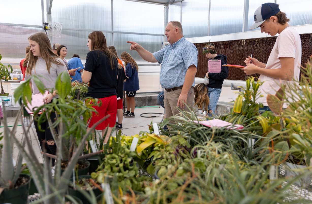 Chad Warnick, center, guides his students during a lab inside the greenhouse at the Delta Technical Center, a technical high school in Delta, on Monday.