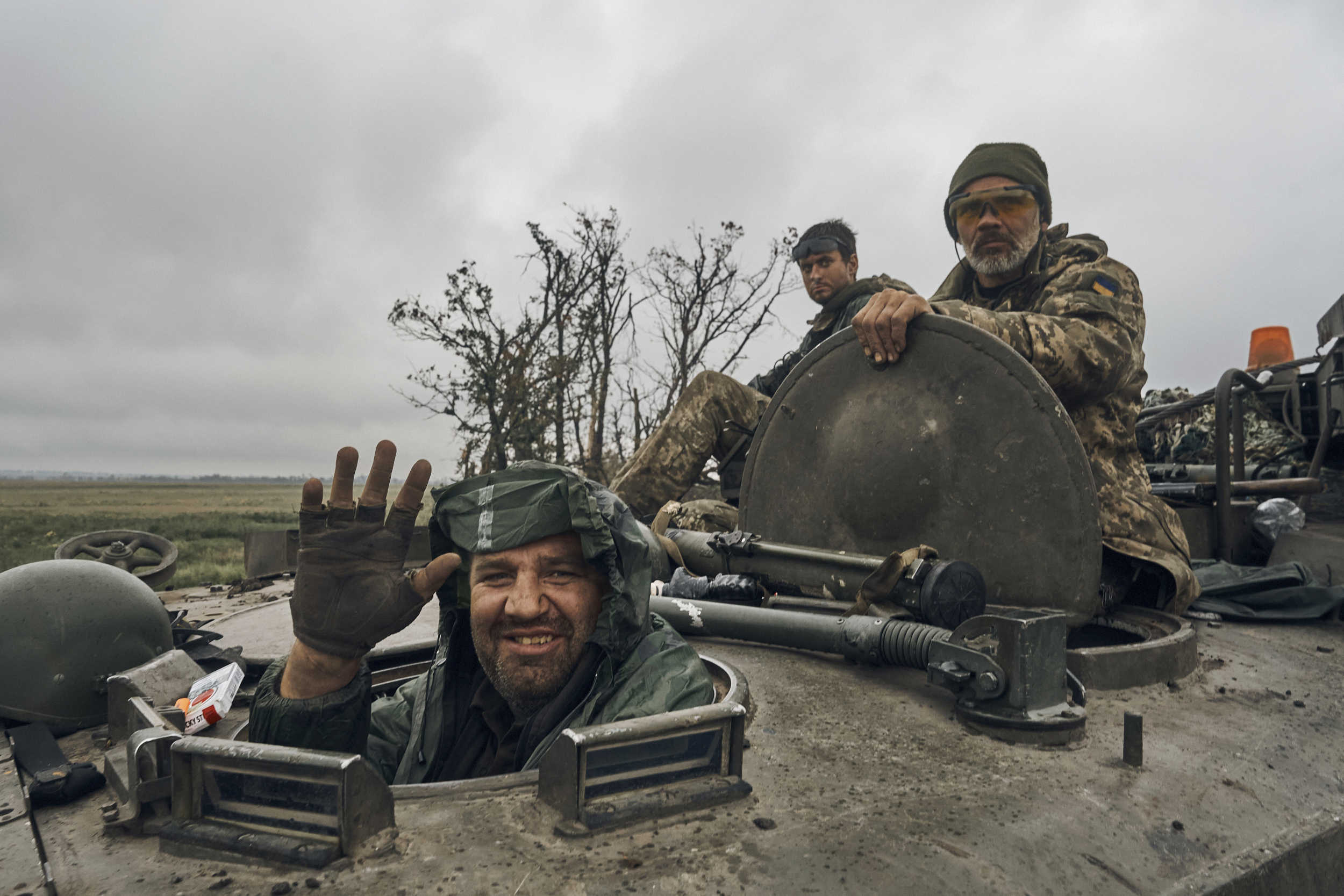 A Ukrainian soldier smiles from a military vehicle on the road in the freed territory in the Kharkiv region, Ukraine, Monday. Ukrainian troops are piling pressure on retreating Russian forces Tuesday.