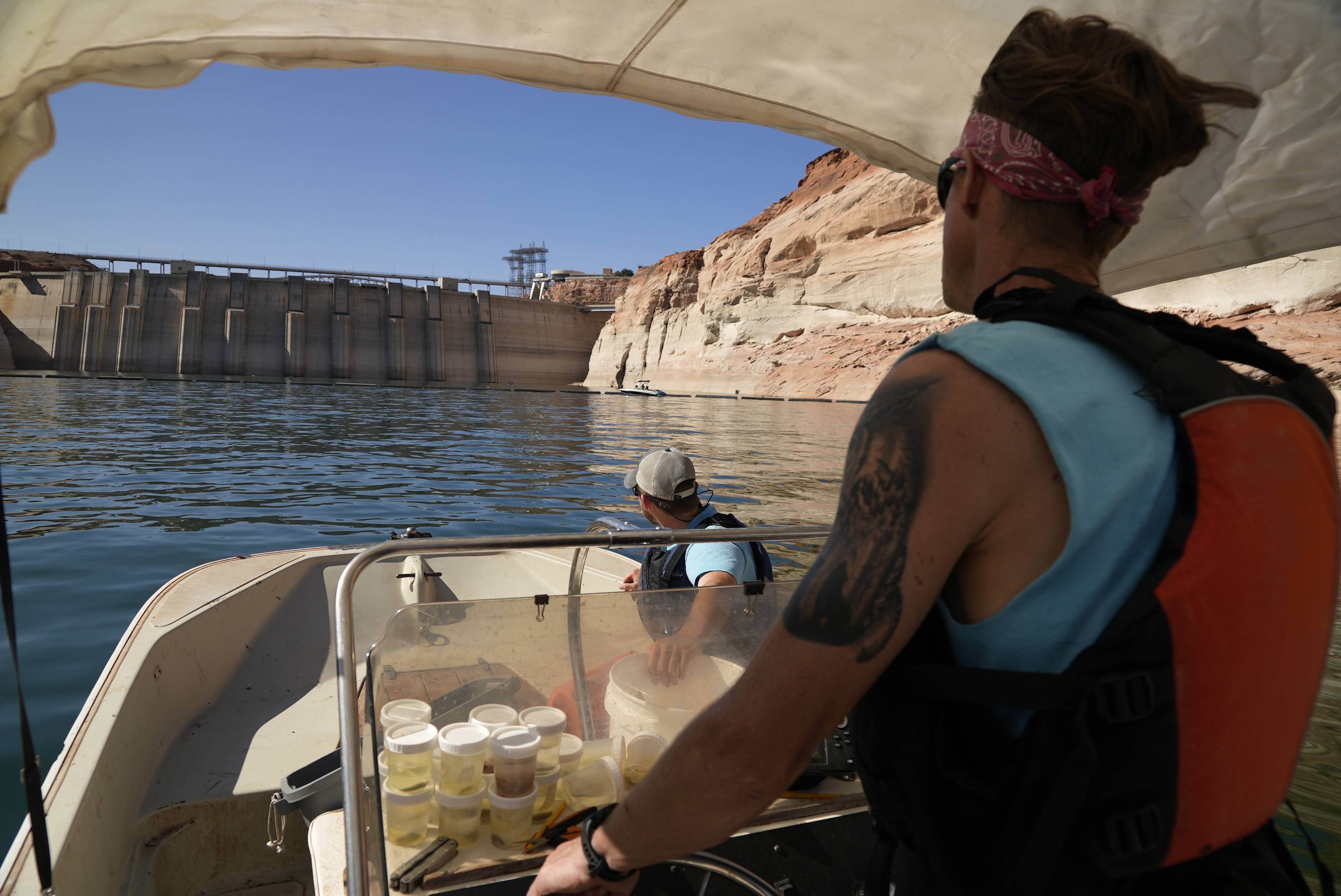 Utah State University master's student Barrett Friesen steers a boat near Glen Canyon Dam on Lake Powell on June 7, in Page, Ariz. In Arizona, water officials are concerned, though not panicking, about getting water in the future from the Colorado River.