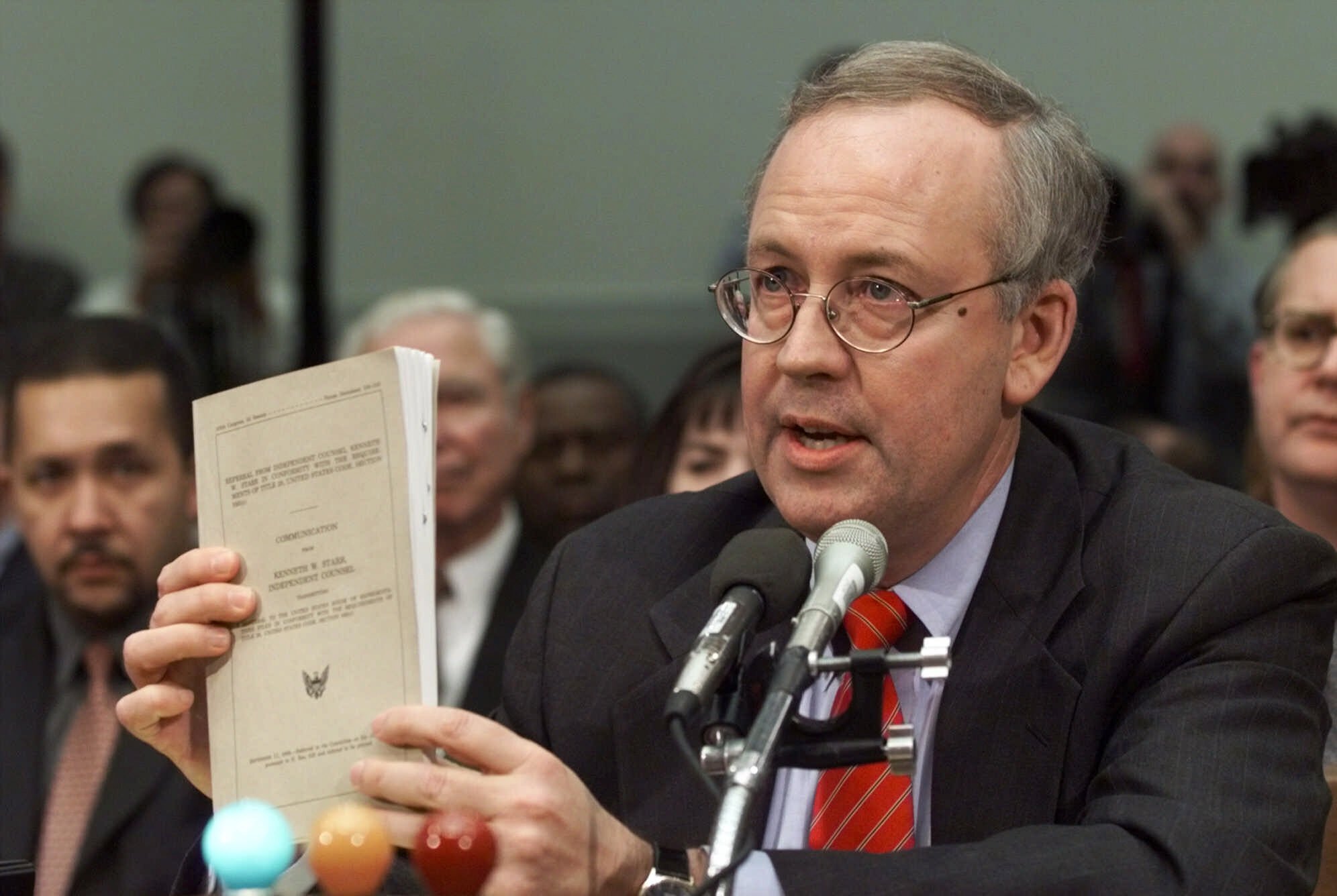Independent Counsel Kenneth Starr holds a copy of his report while testifying on Capitol Hill, Nov. 19, 1998, before the House Judiciary Committee's impeachment hearing. Starr, whose criminal investigation of Bill Clinton led to the president’s impeachment, died Tuesday. He was 76.