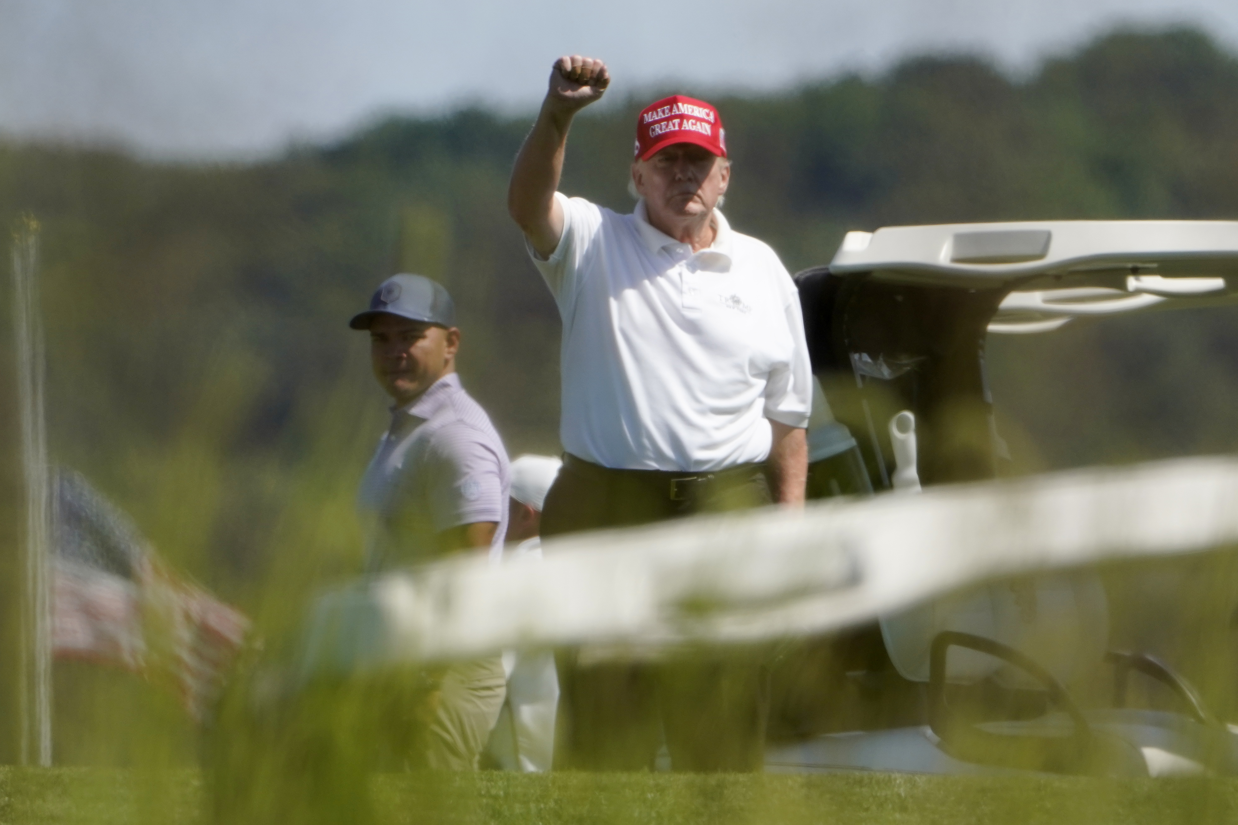 Former President Donald Trump gestures while playing golf at Trump National Golf Club in Sterling, Va., Tuesday. A federal judge has unsealed additional portions of an FBI affidavit laying out the basis for a search of Trump's Florida home.