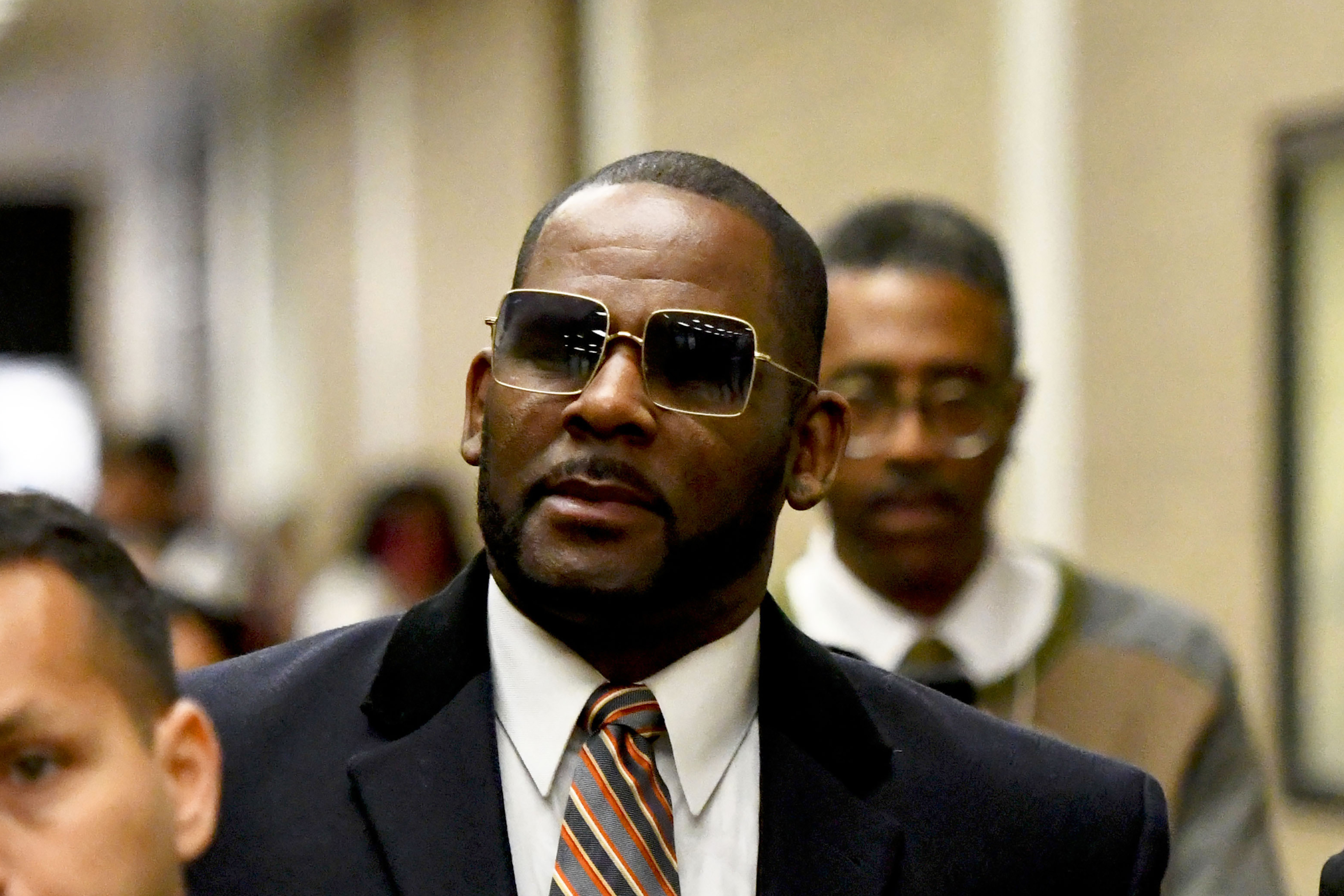 Musician R. Kelly, center, leaves the Daley Center after a hearing in his child support case on May 8, 2019, in Chicago. A federal jury has convicted R&B star R. Kelly of child pornography charges in his hometown of Chicago. 