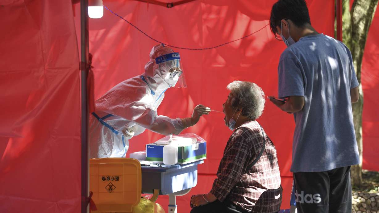 In this photo released by Xinhua News Agency, a medical worker takes a swab sample from a resident for nucleic acid test at a community testing site for COVID-19 in Yunyan District of Guiyang, southwest China's Guizhou Province, Sept. 5. The head of the World Health Organization says the number of coronavirus deaths last week was the lowest reported number in the pandemic since March 2020, marking what could be a turning point in the years-long global outbreak.
