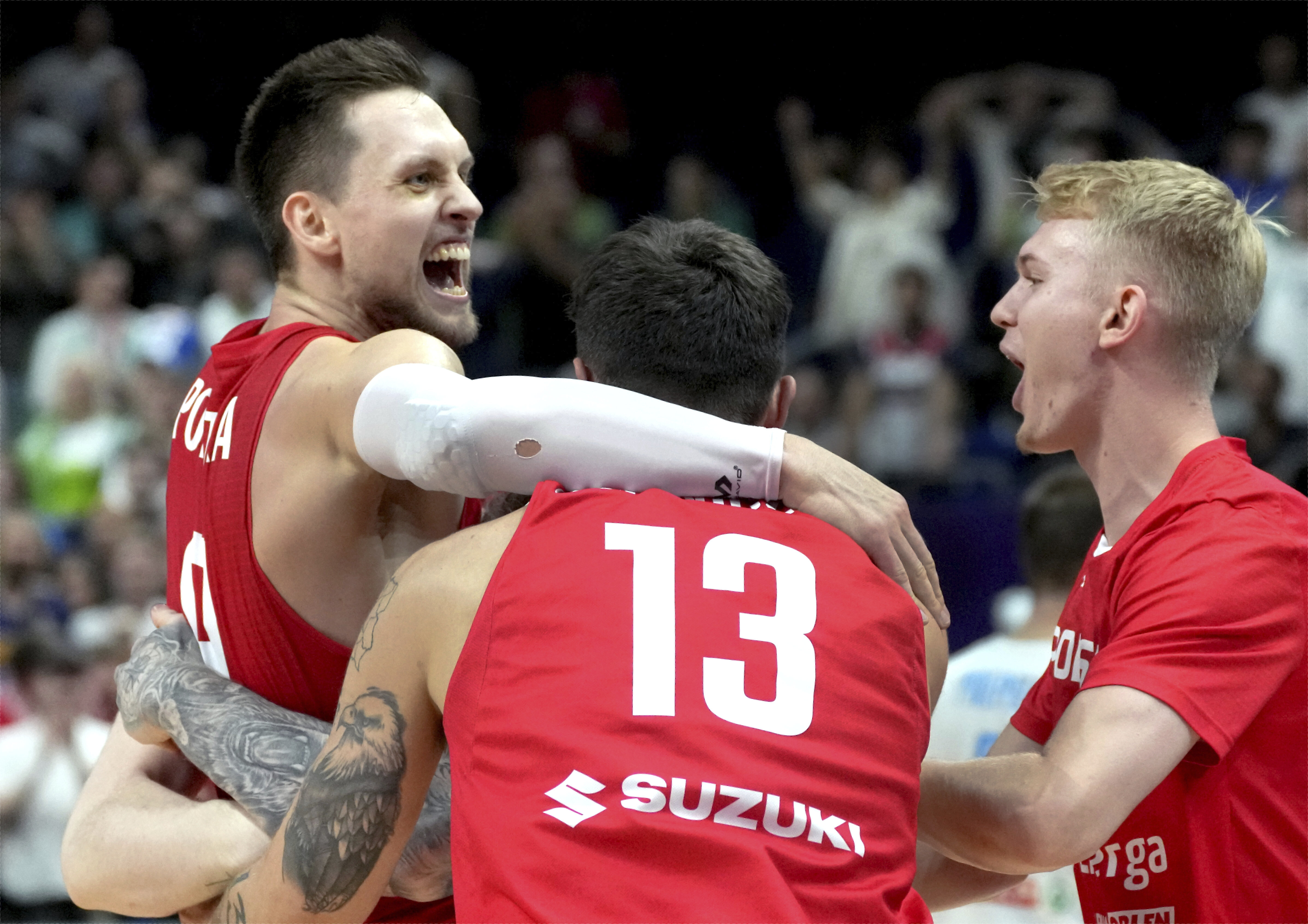 Poland's Mateusz Ponitka, left, and his teammates celebrate after the Eurobasket quarter final basketball match between Slovenia and Poland in Berlin, Germany, Wednesday, Sept. 14, 2022. Poland defeated Slovenia by 90-87. 