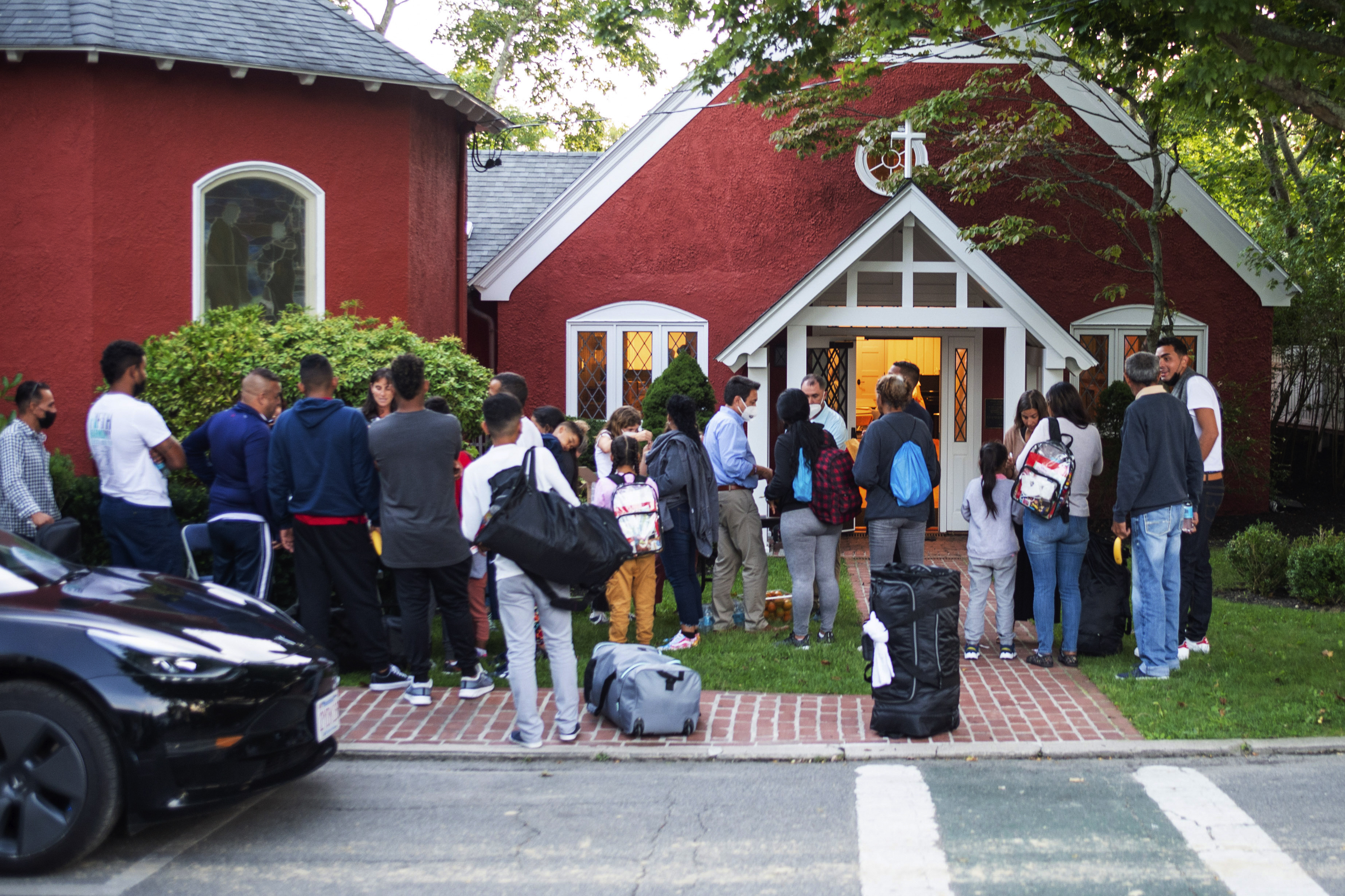 Immigrants gather with their belongings outside St. Andrews Episcopal Church, Wednesday in Edgartown, Mass., on Martha's Vineyard. Republican governors are escalating their partisan tactic of sending migrants to Democratic strongholds without advance warning.