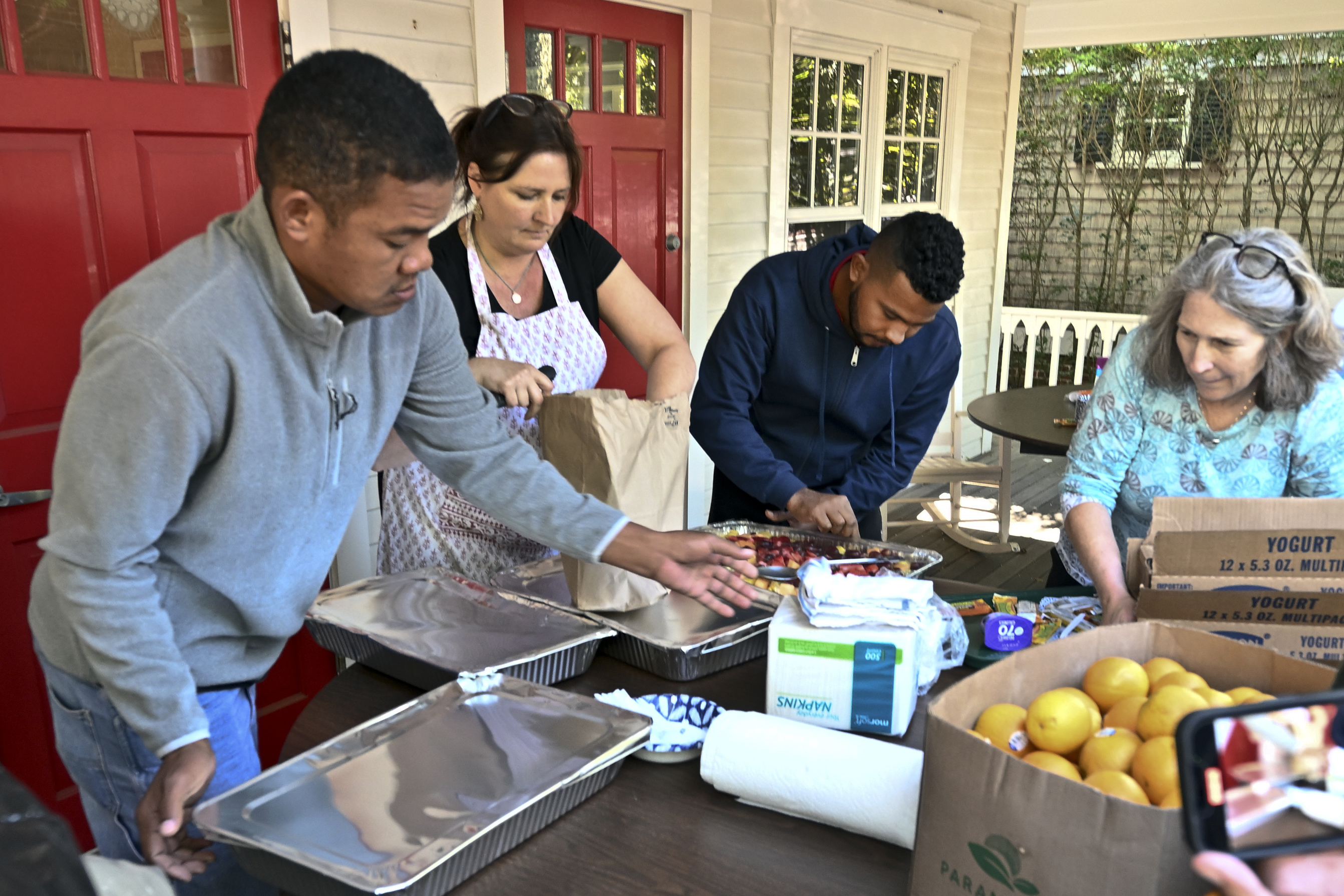 Volunteers prepare food for immigrants outside St. Andrews Episcopal Church, Thursday in Edgartown, Mass., on Martha's Vineyard.