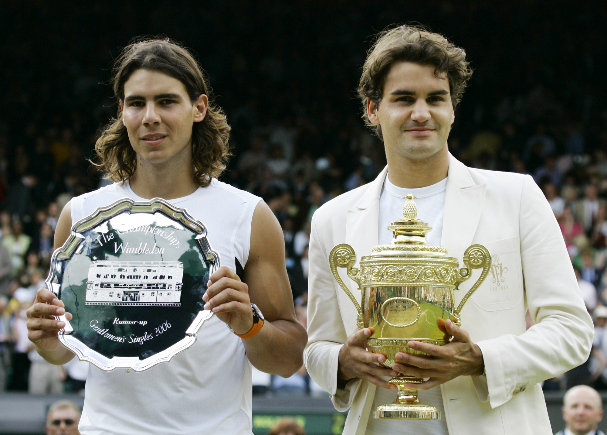 FILE - Defending champion Roger Federer, right, holds the winners trophy with runner up Rafael Nadal of Spain after the Men's Singles final on the Centre Court at Wimbledon, Sunday July 9, 2006. Federer won the match 6-0, 7-6, 6-7, 6-3. Federer announced Thursday, Sept.15, 2022 he is retiring from tennis.