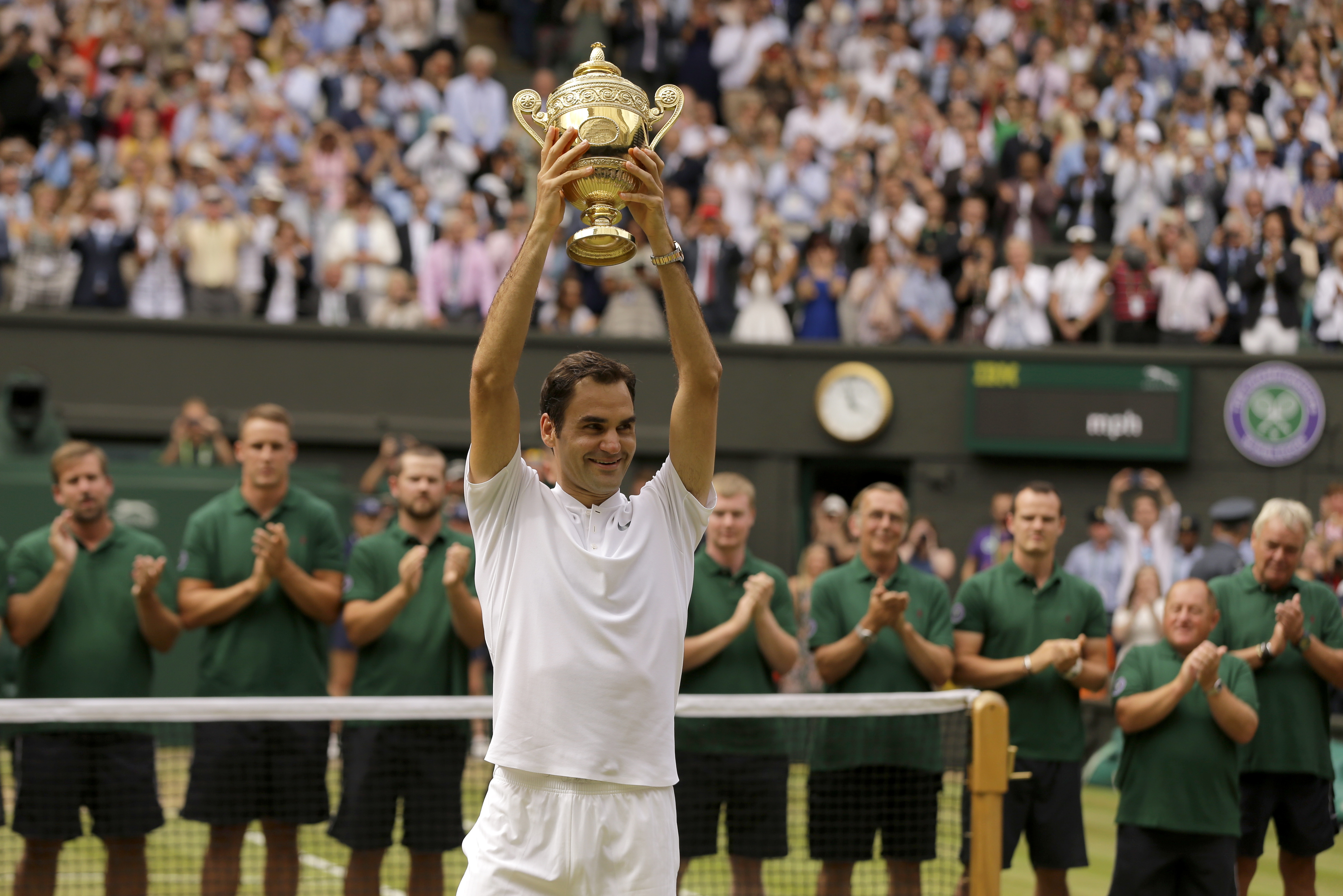 FILE - Switzerland's Roger Federer is applauded by ground staff as he holds the trophy after defeating Croatia's Marin Cilic to win the Men's Singles final match on day thirteen at the Wimbledon Tennis Championships in London Sunday, July 16, 2017. Federer announced Thursday, Sept.15, 2022 he is retiring from tennis. 