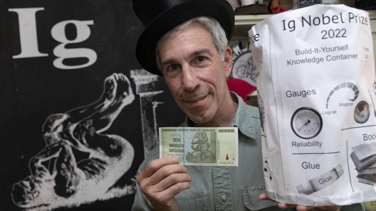 Master of Ceremonies Marc Abrahams poses with the 2022 Ig Nobel prize, Sept. 9, at his office in Cambridge, Mass. The annual prize ceremony on Thursday was for the third year in a row a prerecorded affair because of the lingering effects of the coronavirus pandemic.