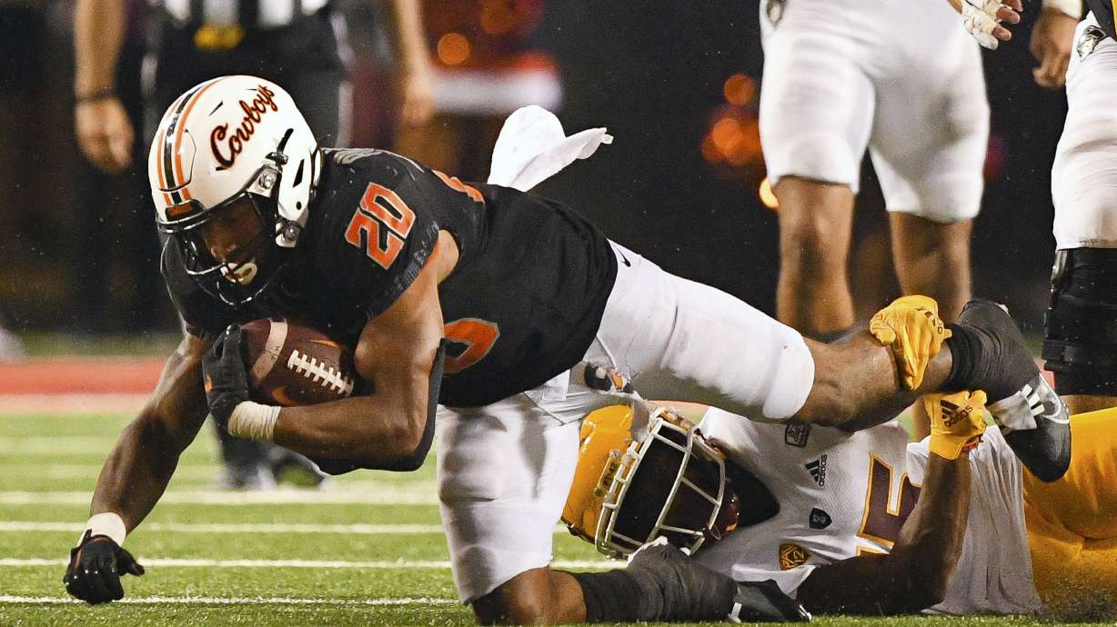 Oklahoma State running back Dominic Richardson (20) attempts to escape the ankle tackle of Arizona State defensive back Khoury Bethley (15) during the second half of an NCAA college football game, Saturday, Sept. 10, 2022, in Stillwater, Okla. Oklahoma State defeated Arizona State 34-17.