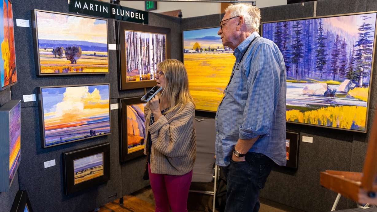 Dana Sanders, left, talks to artist Martin Blundell at his booth during Art at The Park at This Is The Place Heritage Park in Salt Lake City on Friday.