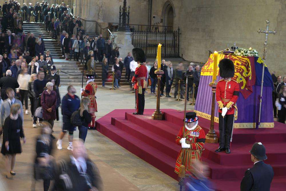 Members of the public file past the coffin of Queen Elizabeth II, draped in the Royal Standard with the Imperial State Crown and the Sovereign's orb and sceptre, lying in state on the catafalque, in Westminster Hall, at the Palace of Westminster, in London, Friday, ahead of her funeral on Monday.