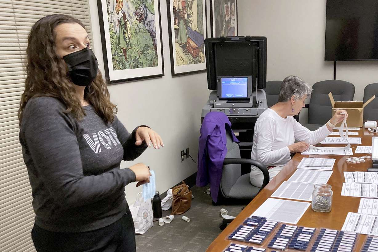 Rachel Rodriguez, left, the elections management specialist for Dane County, Wis., looks over a table of ballots being tested before being sent to more than 200 voting locations across the state's second-largest county on Wednesday, in Madison, Wis. Her office is among those that have been hammered with requests by what appear to be coordinated campaigns by groups who reject the results of the 2020 presidential election.