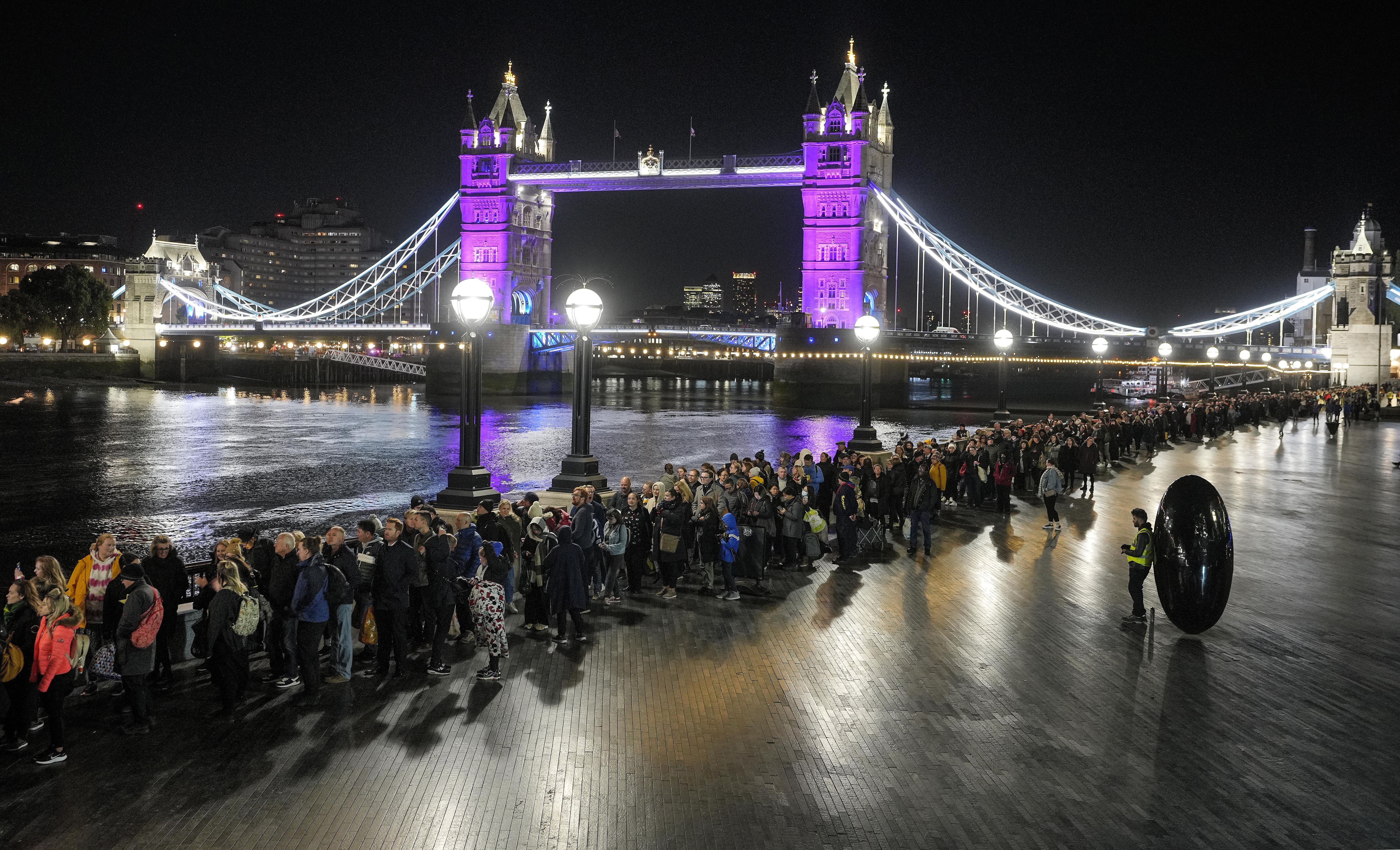 People queue in front of Tower Bridge to pay their respect to the late Queen Elizabeth II during the Lying-in State at Westminster Hall in London, early Saturday morning. The queen will lie in state in Westminster Hall for four full days before her funeral on Monday. 
