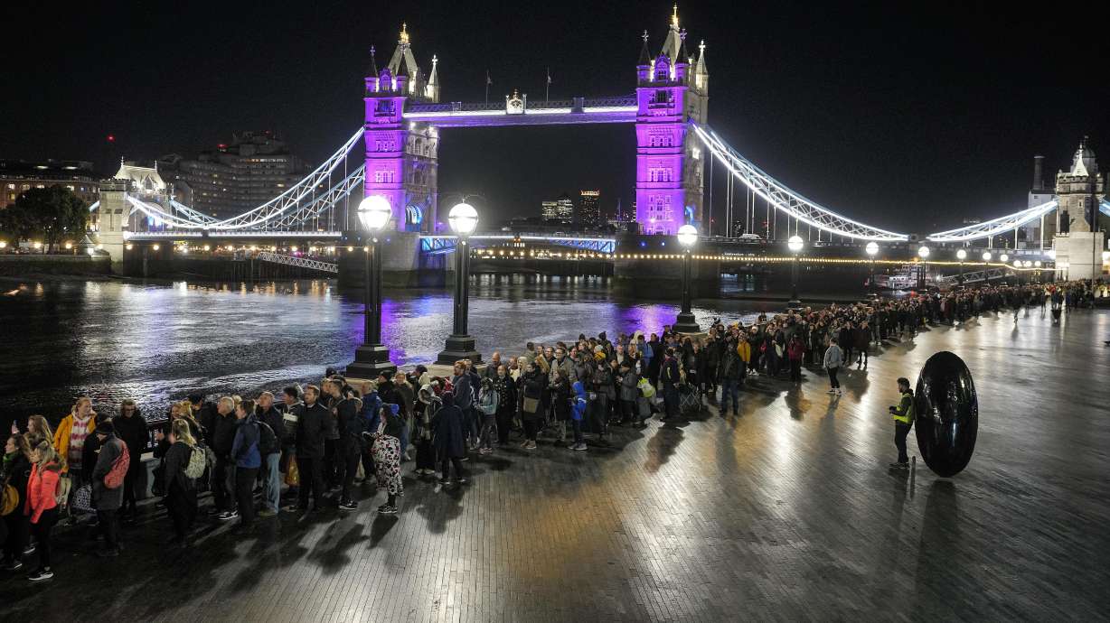 People queue in front of Tower Bridge to pay their respect to the late Queen Elizabeth II during the Lying-in State at Westminster Hall in London, early Saturday morning. The queen will lie in state in Westminster Hall for four full days before her funeral on Monday.