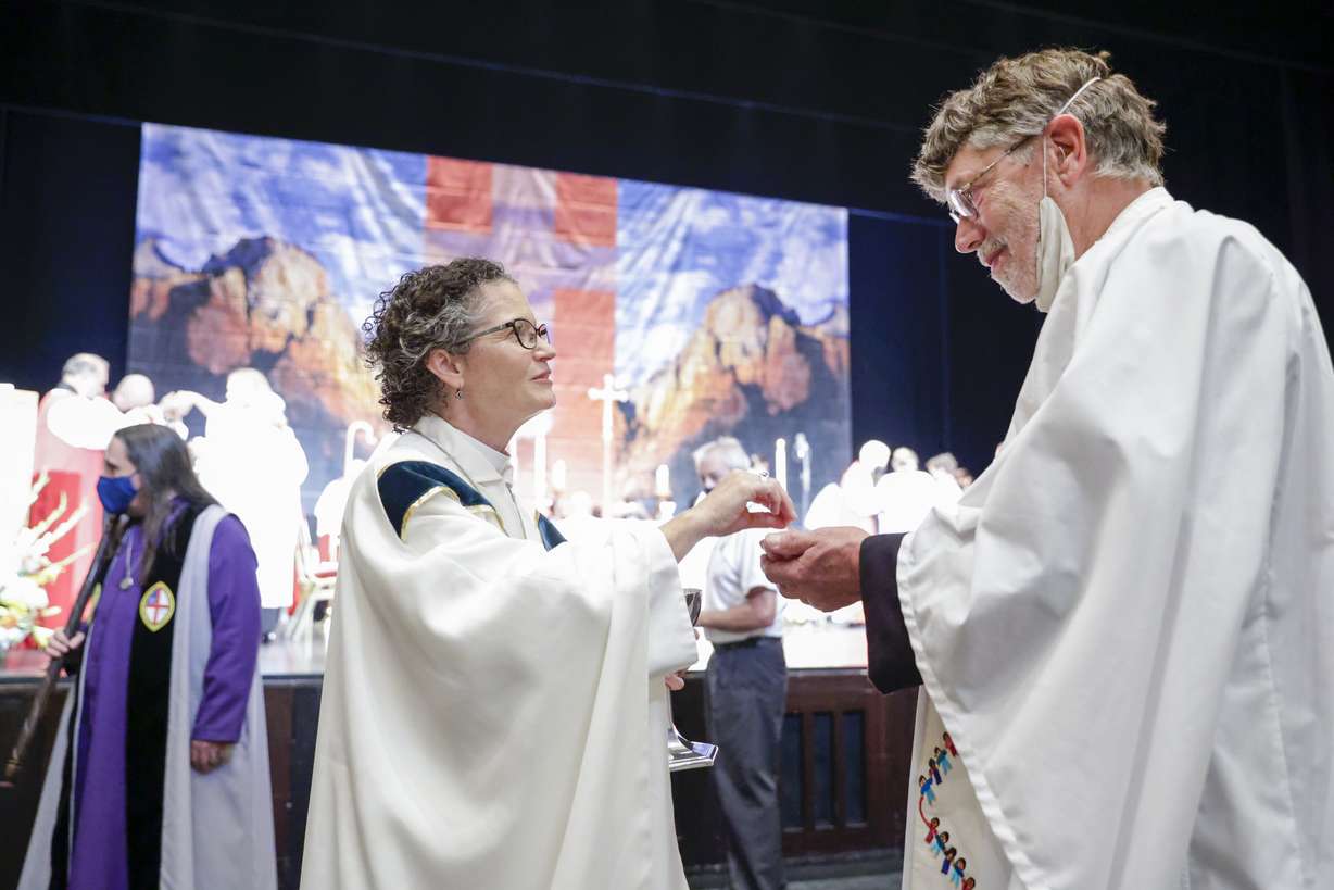 Phyllis Spiegel is ordained as a bishop and hands sacramental bread to Rev. Michael Carney inside the Capitol Theatre in Salt Lake City on Saturday.