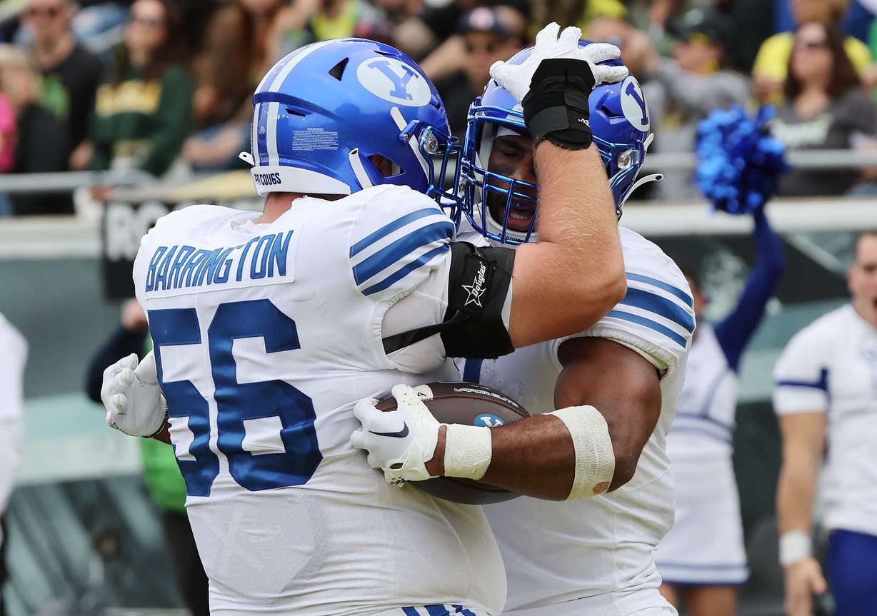 Brigham Young Cougars running back Christopher Brooks (2) celebrates a touchdown with Brigham Young Cougars offensive lineman Clark Barrington (56) at Autzen Stadium in Eugene on Saturday, Sept. 17, 2022.
