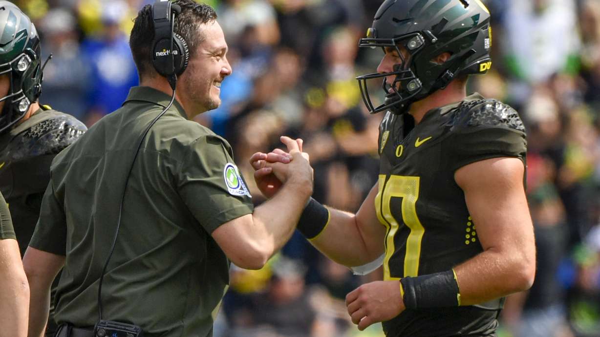 Oregon head coach Dan Lanning greets Oregon quarterback Bo Nix (10) after a touchdown against BYU during the first half of an NCAA college football game, Saturday, Sept. 17, 2022, in Eugene, Ore.