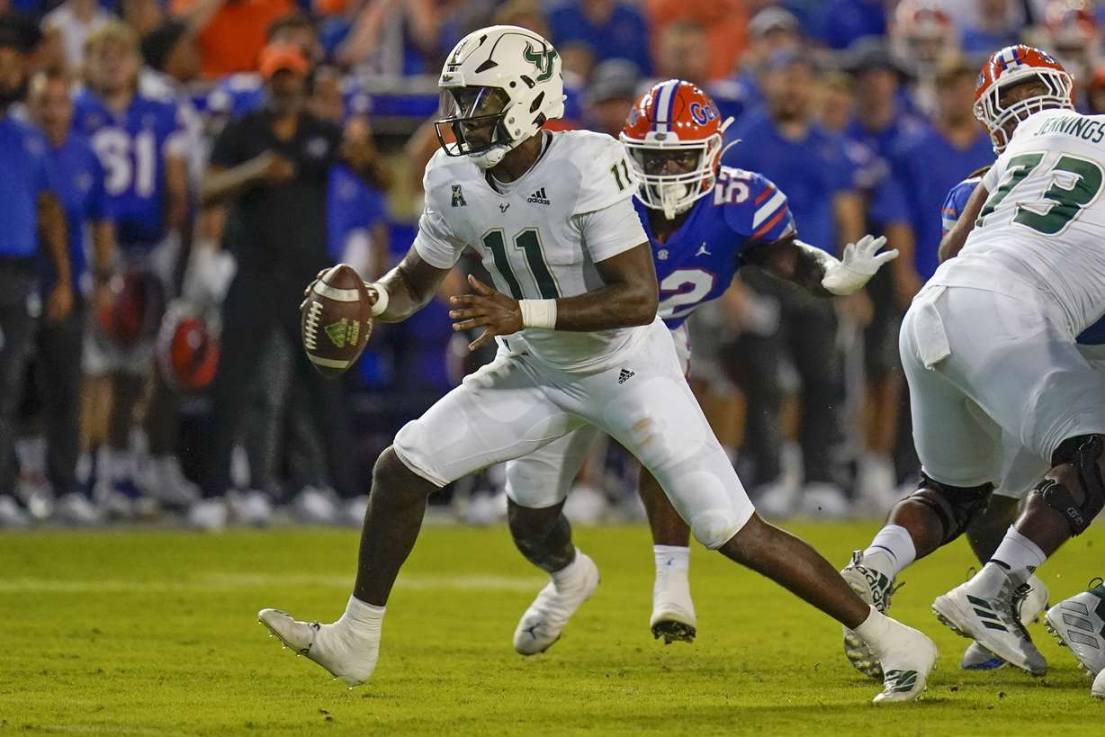 South Florida quarterback Gerry Bohanon (11) looks to pitch the ball as he is pressured by Florida linebacker Antwaun Powell-Ryland Jr. (52) during the first half of an NCAA college football game, Saturday, Sept. 17, 2022, in Gainesville, Fla.