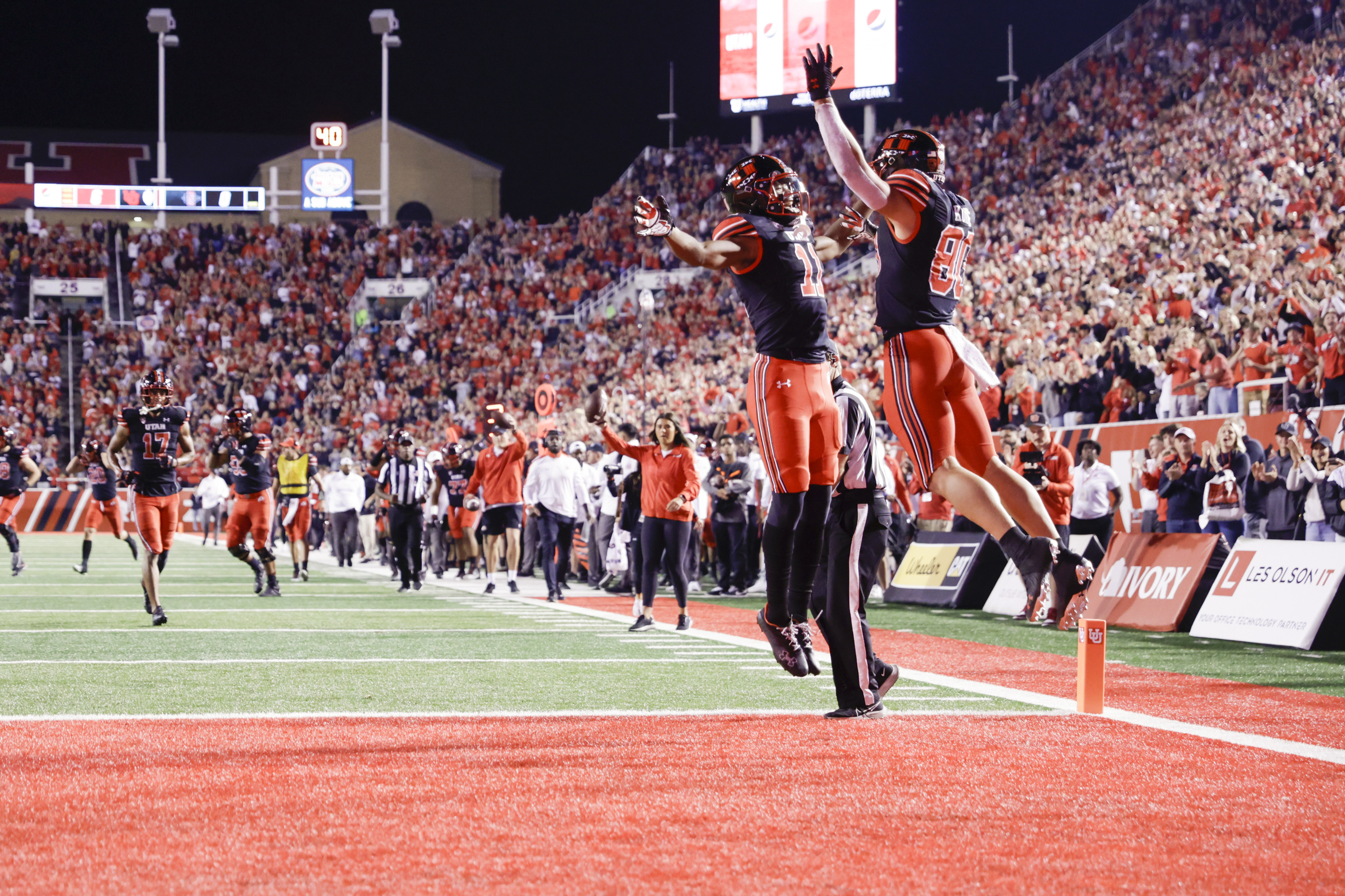 Makai Cope (11) and Brant Kuithe (80) of the Utah Utes jump after scoring a touchdown against the San Diego State Aztecs in Salt Lake City on Saturday, Sept. 17, 2022.