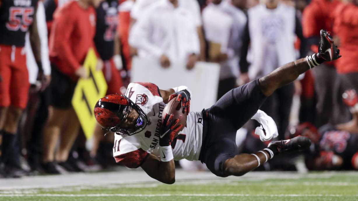 Phillippe Wesley the 2nd of theSan Diego State Aztecs falls from a hit while playing the Utah Utes in Salt Lake City on Saturday, Sept. 17, 2022. The Utes won 35-7.