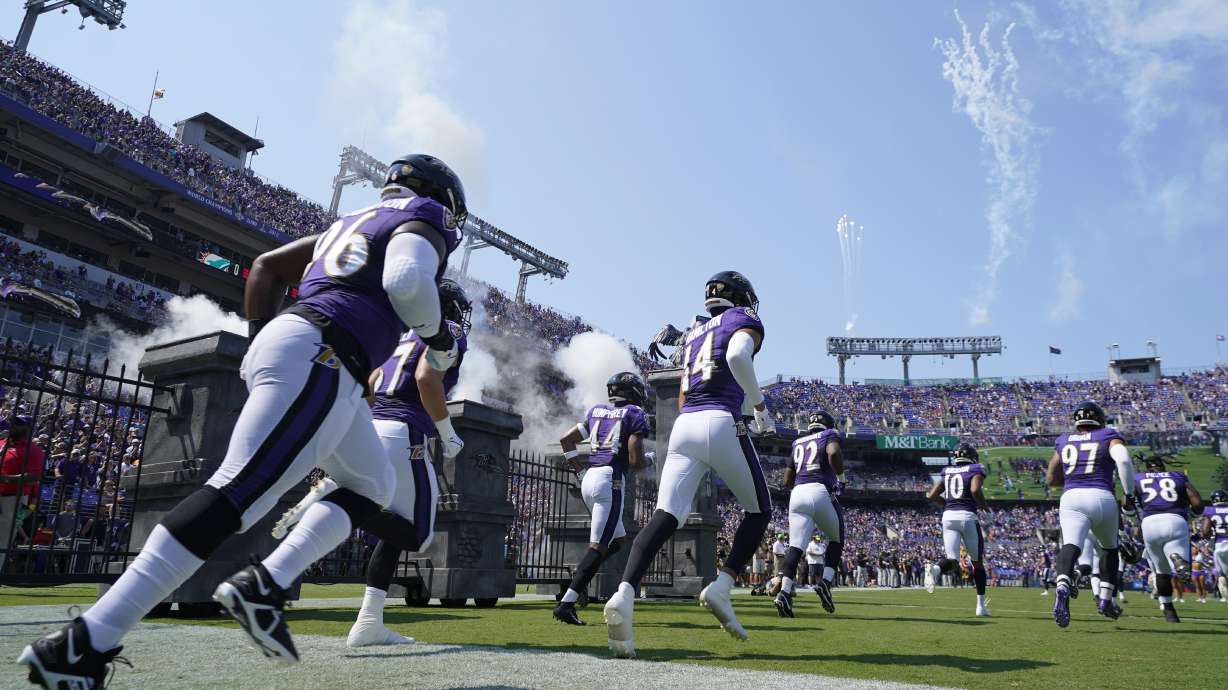 The Baltimore Ravens team enters the field during before an NFL football game against the Miami Dolphins, Sunday, Sept. 18, 2022, in Baltimore.