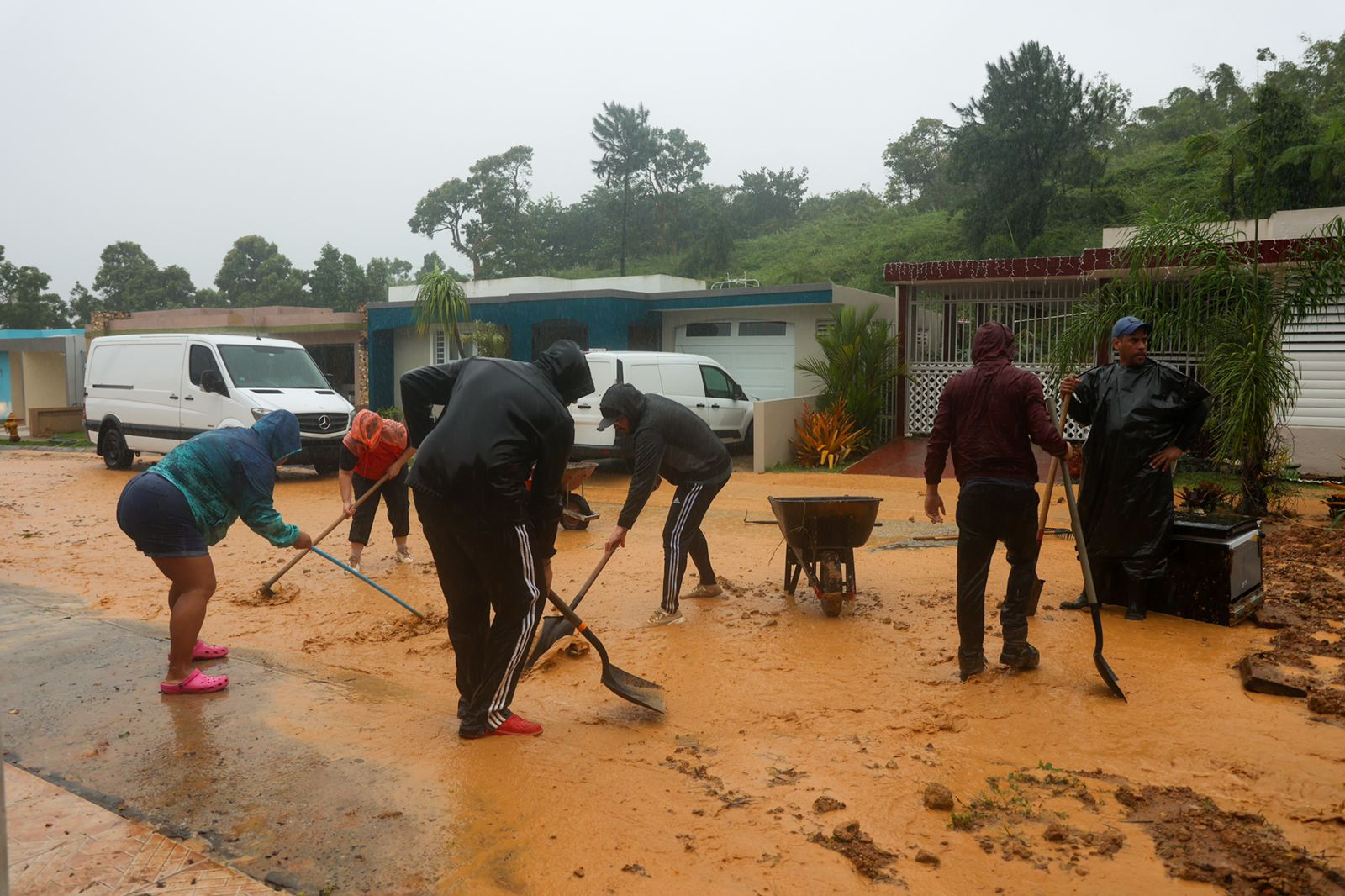 People clean debris from a road after a mudslide caused by Hurricane Fiona in Cayey, Puerto Rico, Sunday.