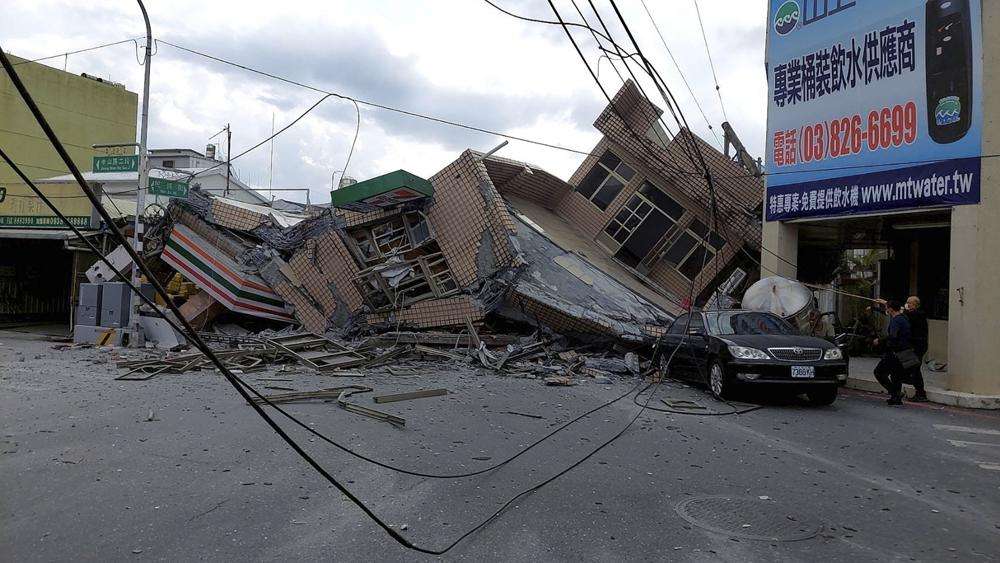 A collapsed residential building is seen following an earthquake in Yuli township in Hualien County, eastern Taiwan, Sunday. A 7-Eleven convenience store was at the first floor of the collapse building. A strong earthquake shook much of Taiwan on Sunday, toppling at least one building and trapping two people inside and knocking part of a passenger train off its tracks at a station.