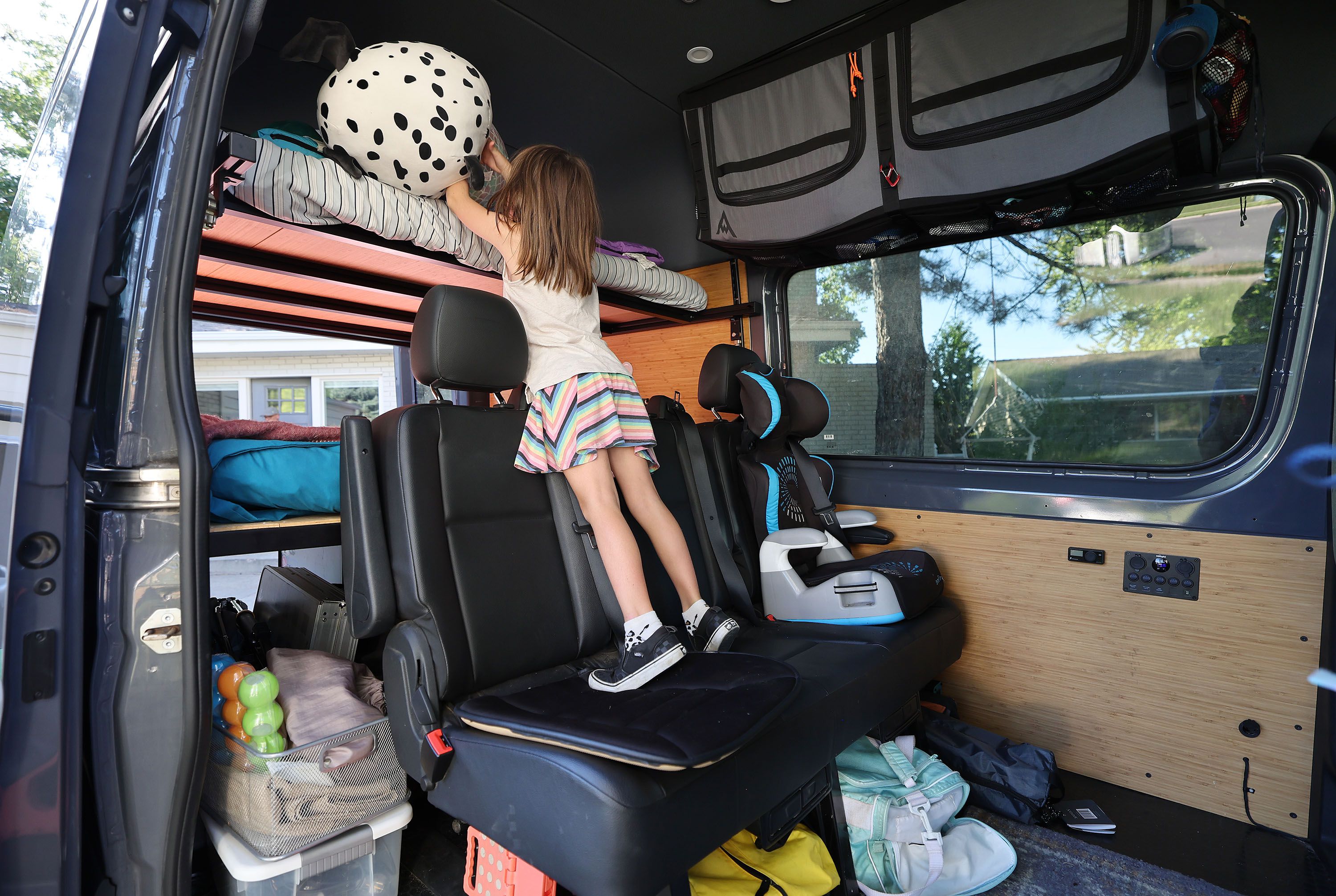 Teagan Miller, 8, loads her things in a van as the family packs for the road trip at their home in Murray on Sept. 2.
