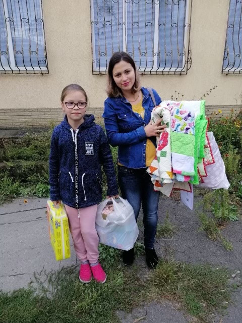 Dwoje ukraińskich dzieci, które otrzymały kołdry z Ukrainy owinięte kołdrami we wschodniej Ukrainie.